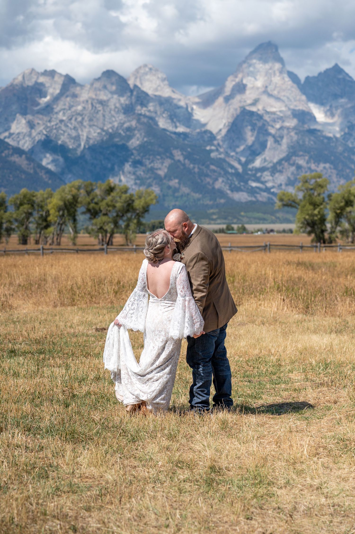 A bride and groom kissing in front of big mountain views after their adventurous elopement in Grand Teton National Park.