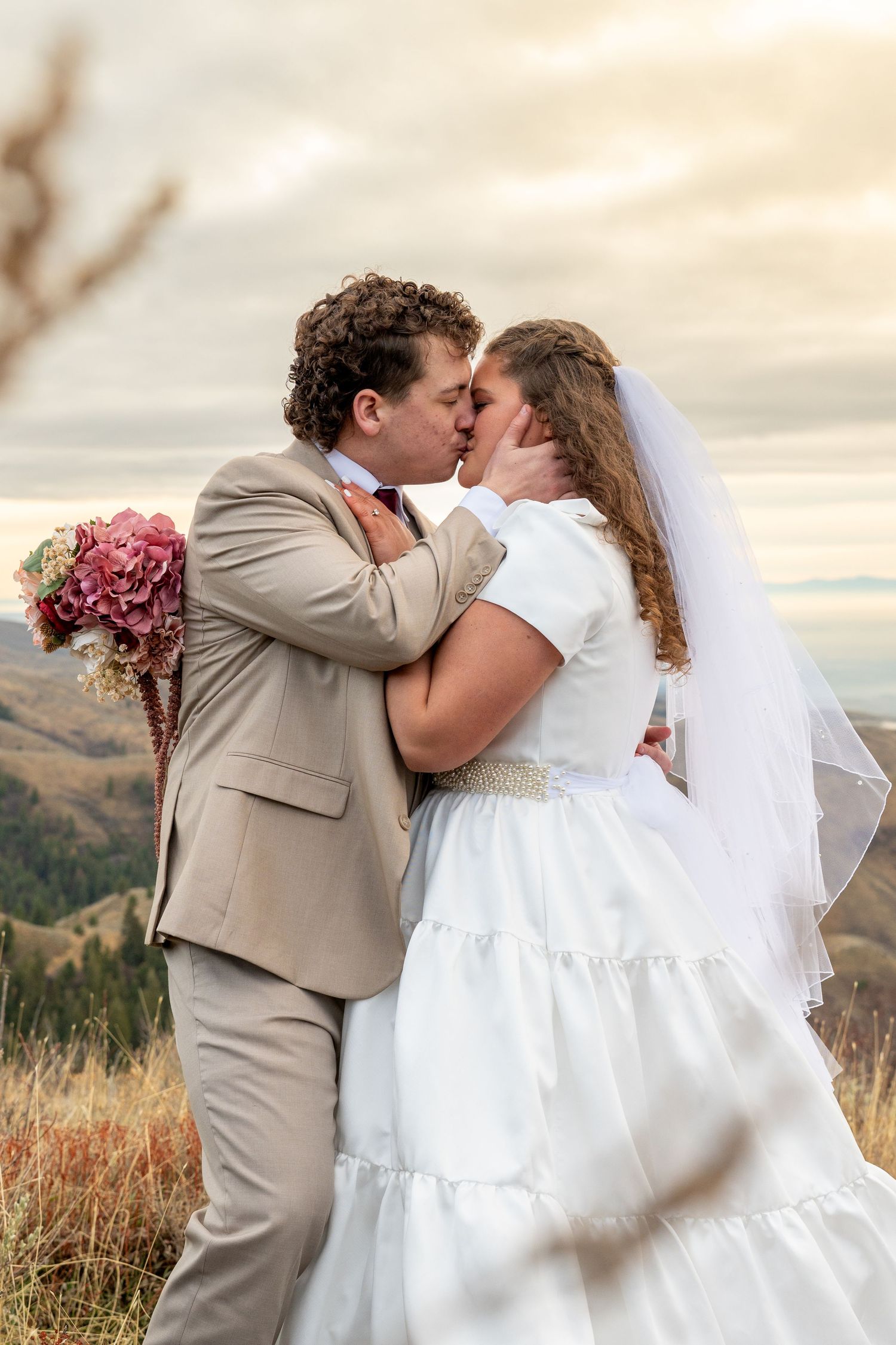 A bride and groom kissing with mountain views in Boise, Idaho