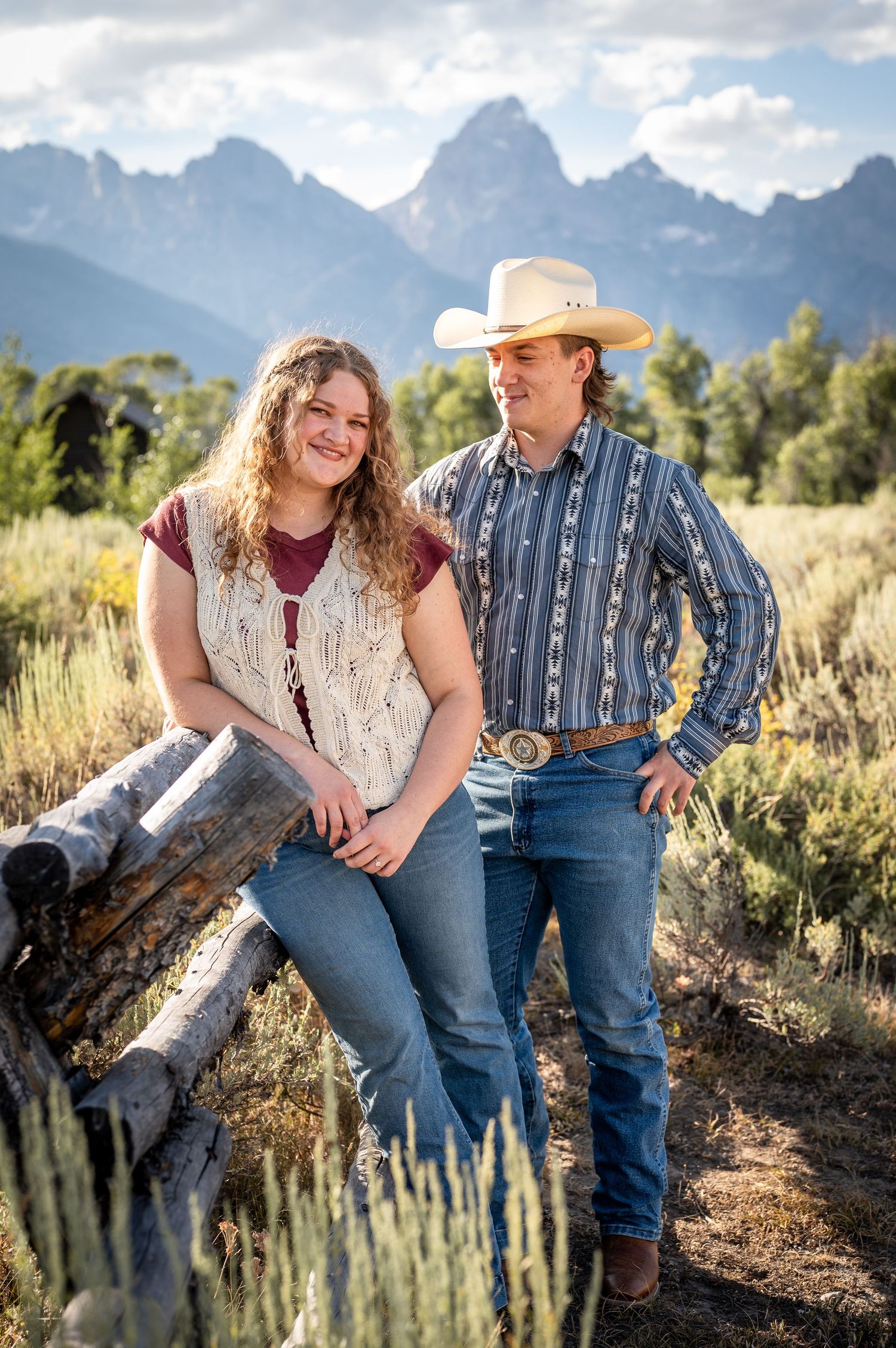 A cute western couple smiles in front of the Tetons in Grand Teton National Park.