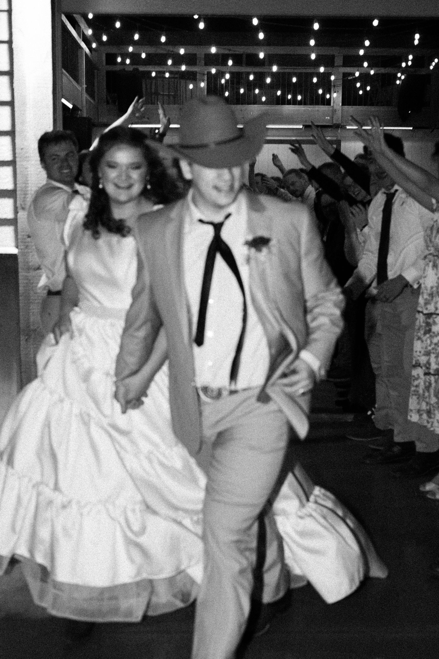 A cinematic and timeless black and white photo of a couple leaving their reception party in Kuna, Idaho
