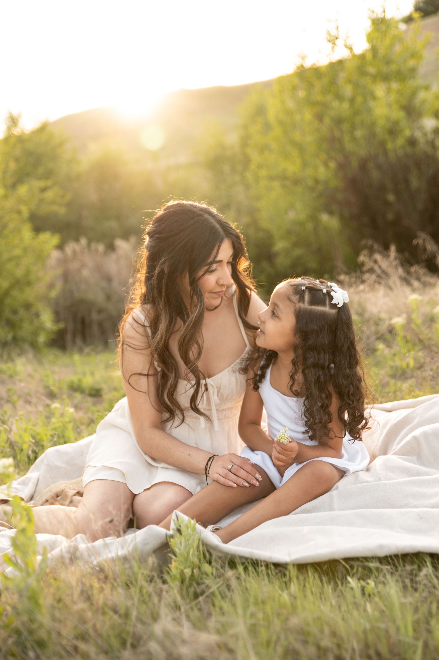 A mom and young daughter looking at each other lovingly during a sunset session at Camels Back Park in Boise, Idaho.