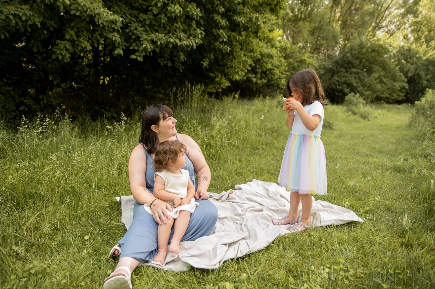 A candid photo of a daughter blowing bubbles to her mom and sister in Boise, Idaho.