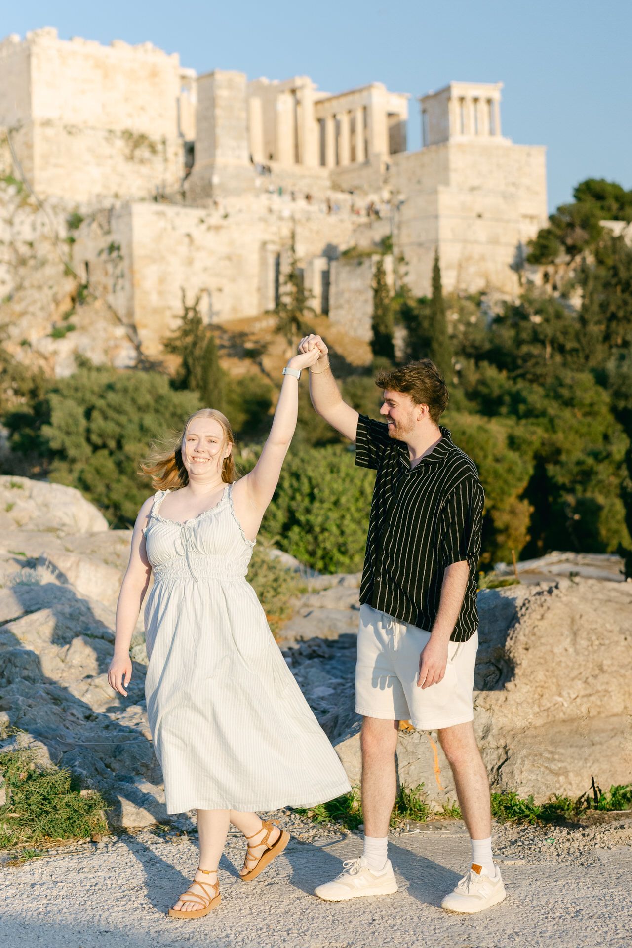 Couple walking in Athens with Acropolis views, editorial travel couple photoshoot in soft natural light.