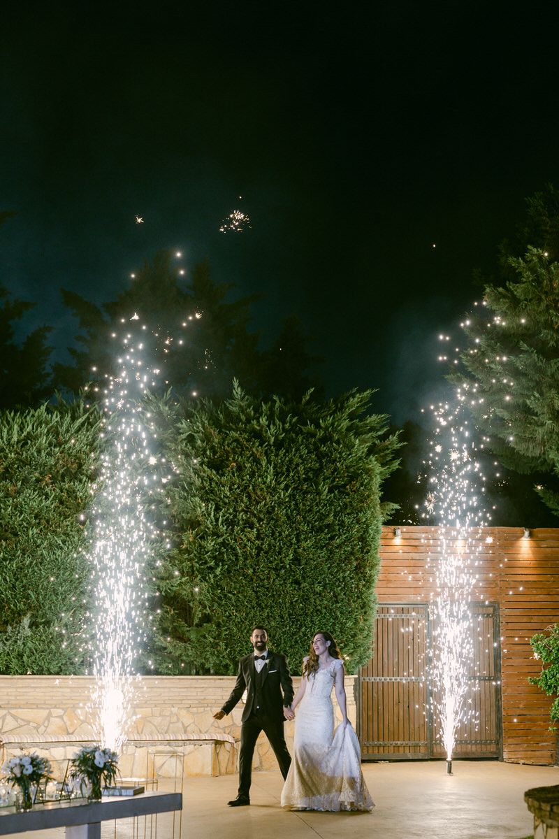 Dramatic sparkler fountains illuminate an outdoor wedding venue at night with magnificent pyrotechnic effects.