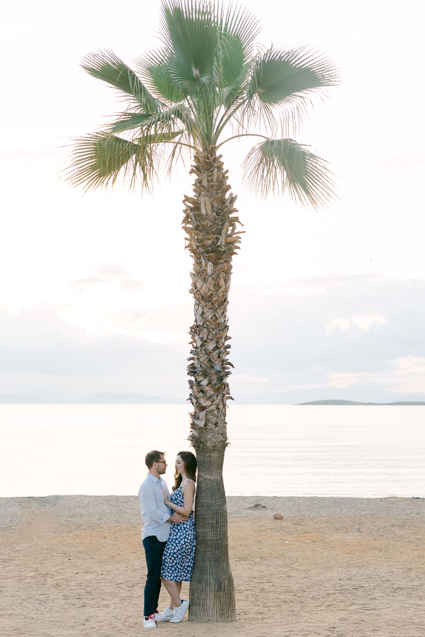 Ρομαντική prewedding φωτογράφιση σε παραλία με ζευγάρι κοντά στο νερό και κομψό αποτέλεσμα