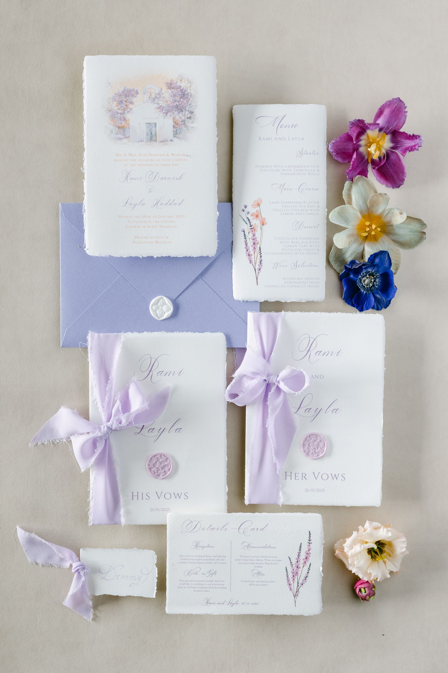 Elegant wedding invitation suite in lavender and white with wax seals, silk ribbons and colorful floral accents.