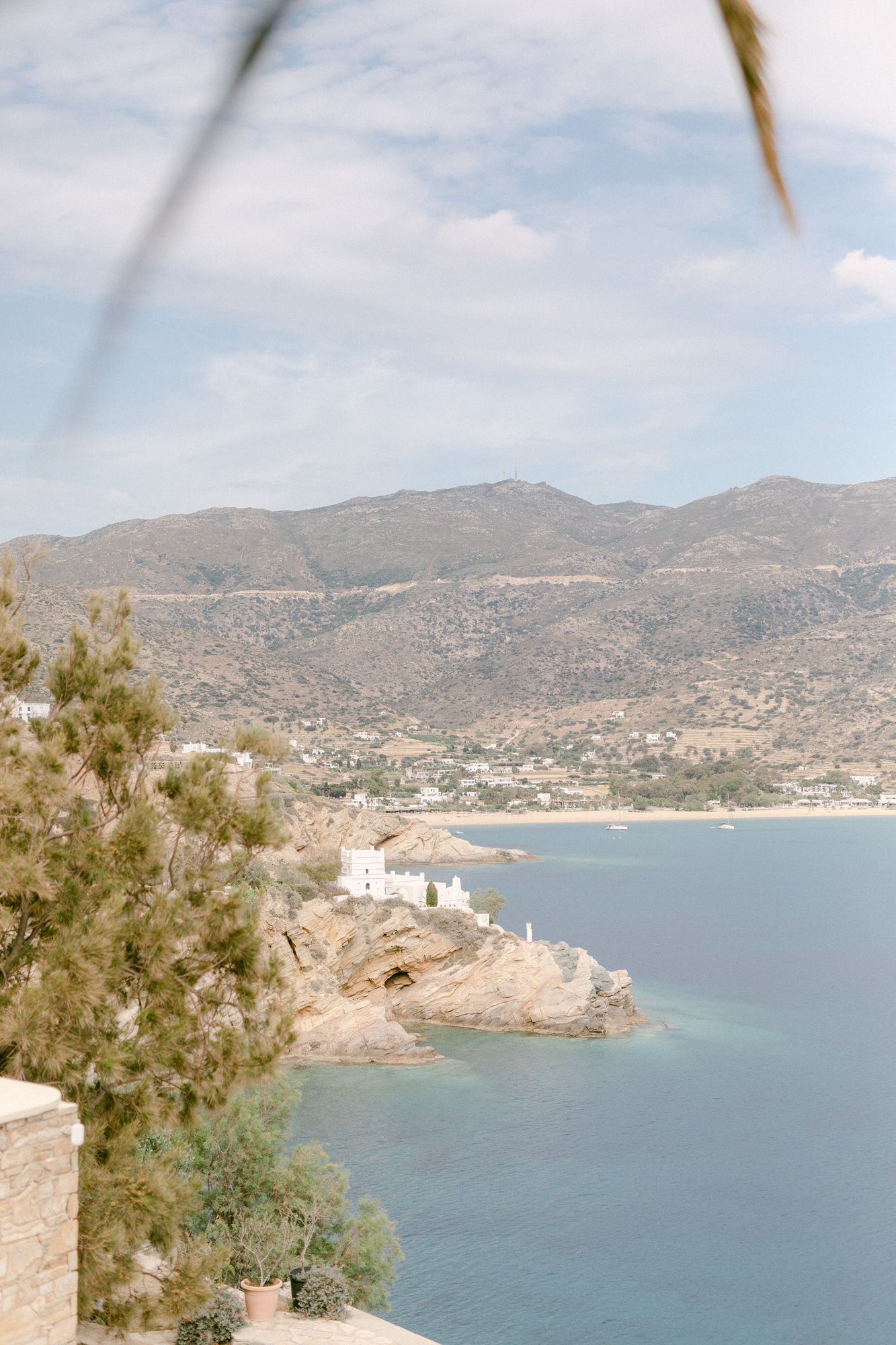 Scenic coastal village nestled in a Mediterranean bay with mountains rising in the background.