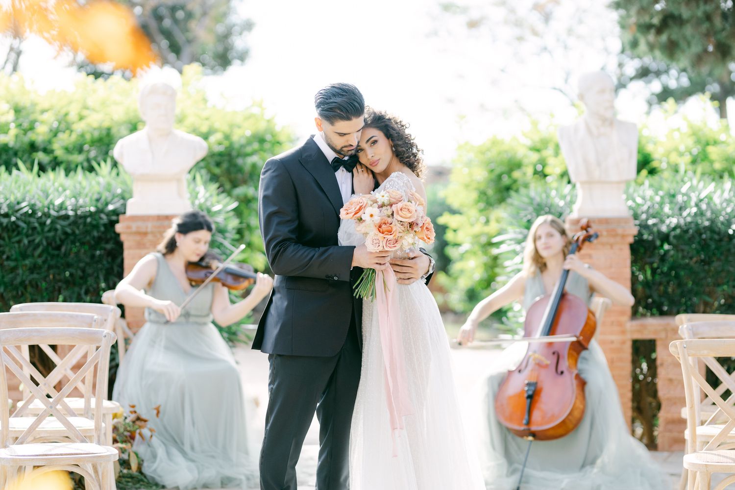 Romantic wedding ceremony with string musicians performing as couple embraces on garden grounds. Πύργος Μελισσουργού Tonia and Theodore