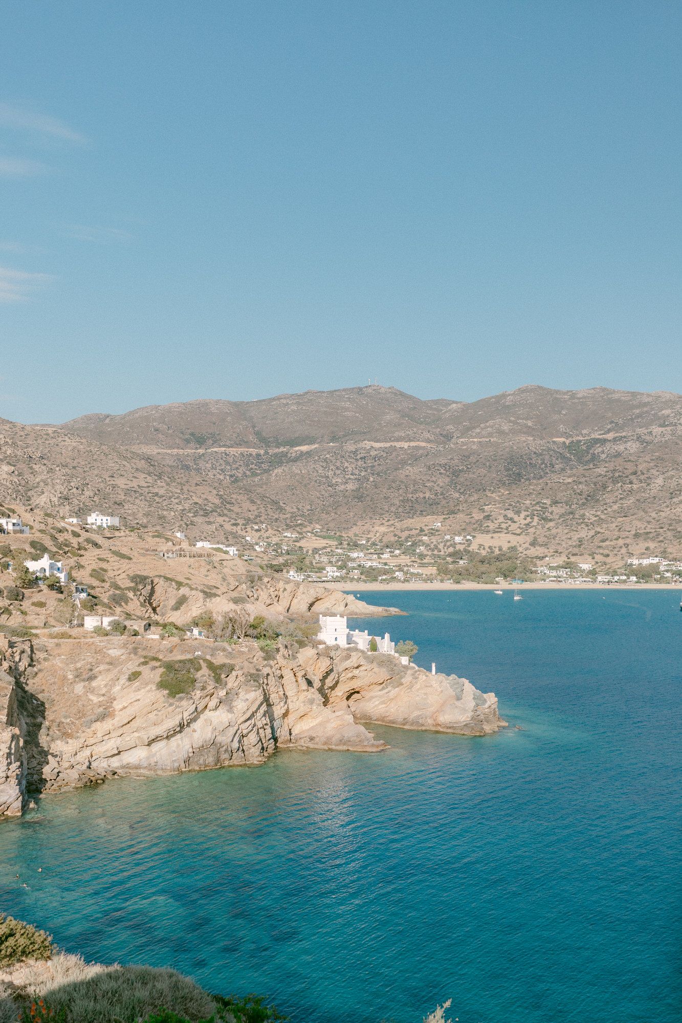 Scenic coastal view of turquoise waters and rocky cliffs in Greece.