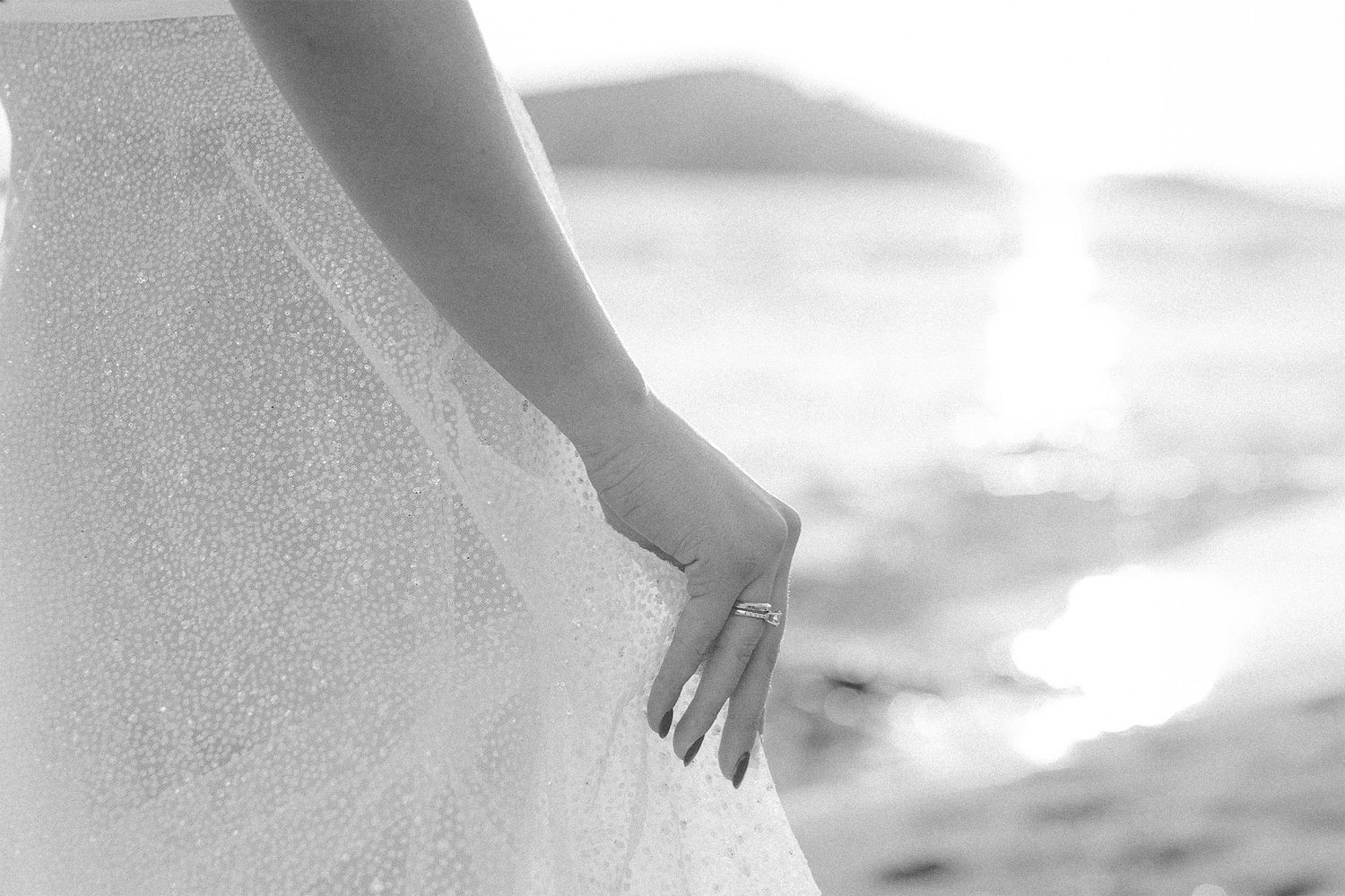 Bride adjusting her dress in sun light during wedding couple session in Athens Riviera Greece.