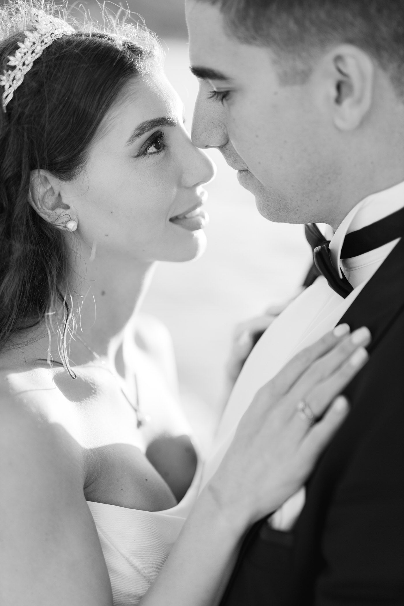 A romantic black and white portrait of a bride and groom in an intimate close-up moment.