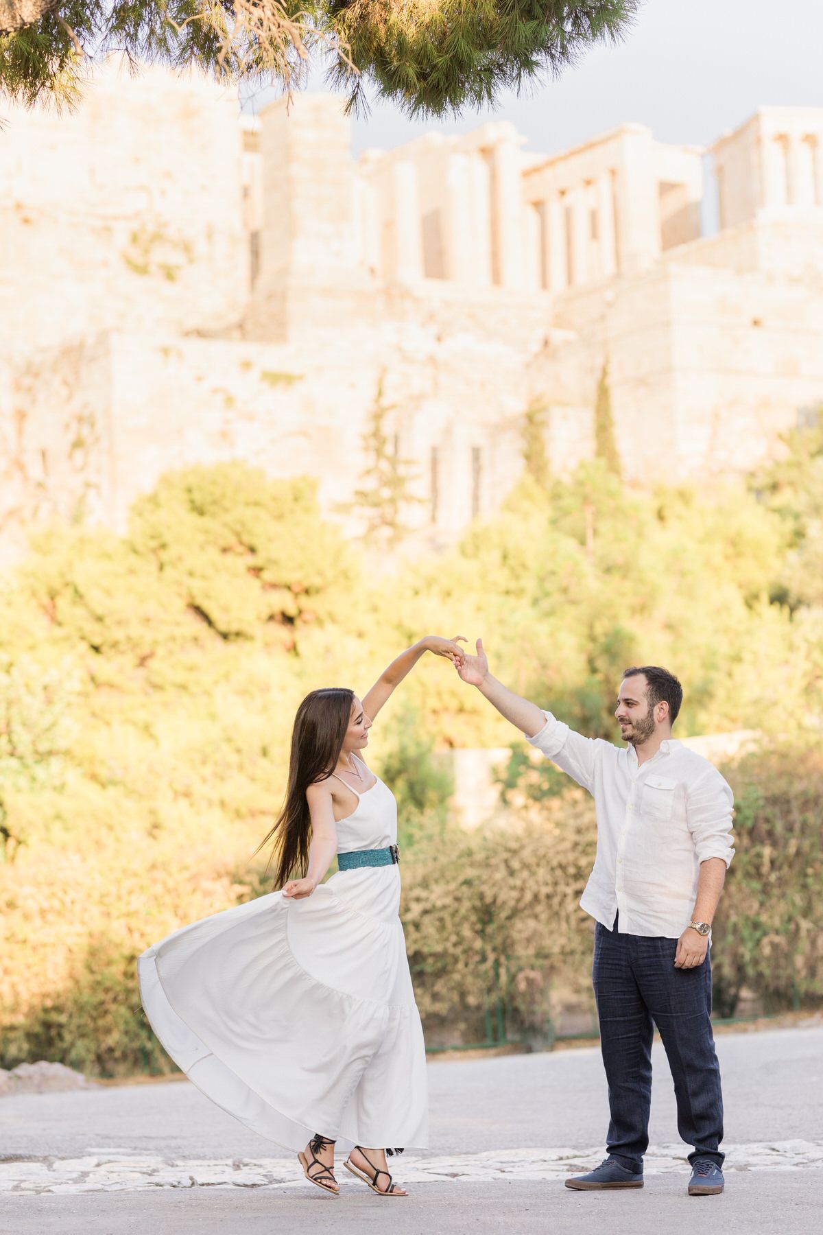A couple dancing against ancient Greek ruins and autumn foliage.