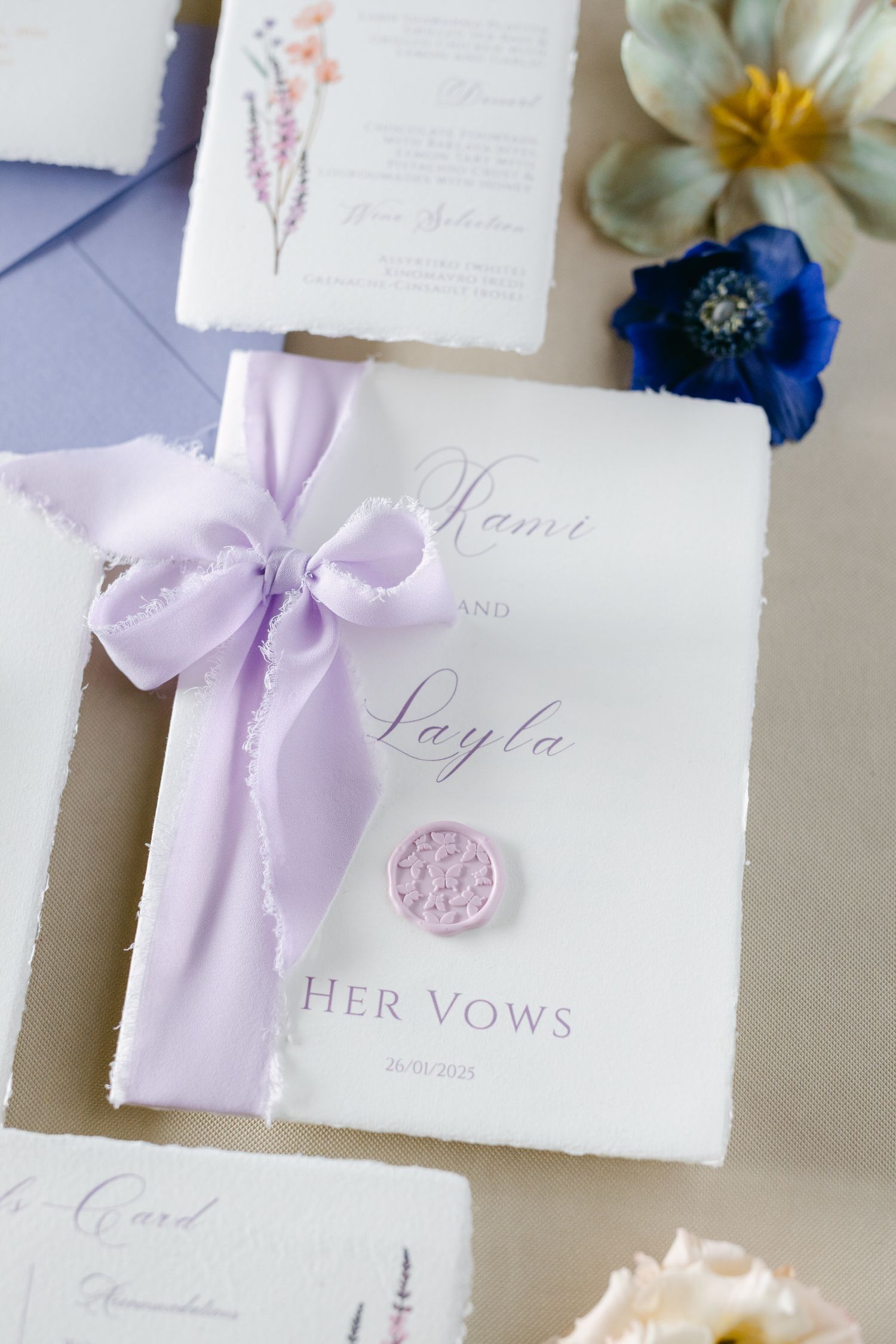 Elegant wedding vows booklet tied with a lavender silk ribbon and decorated with a pink wax seal.