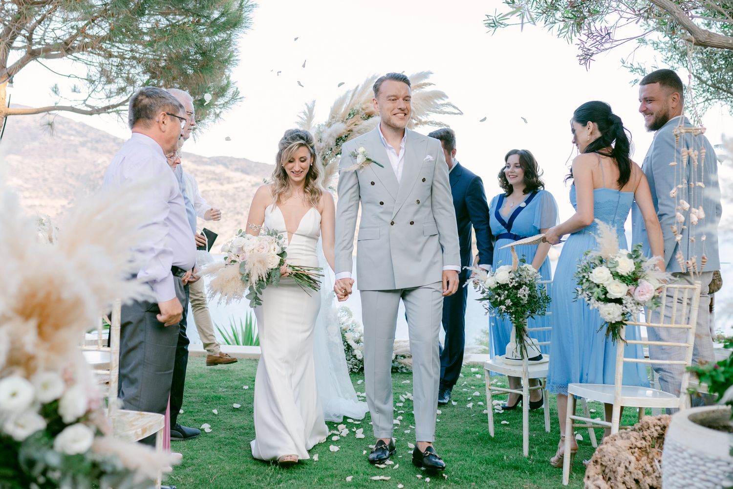 An outdoor wedding ceremony setup with light blue decorations and white chairs.