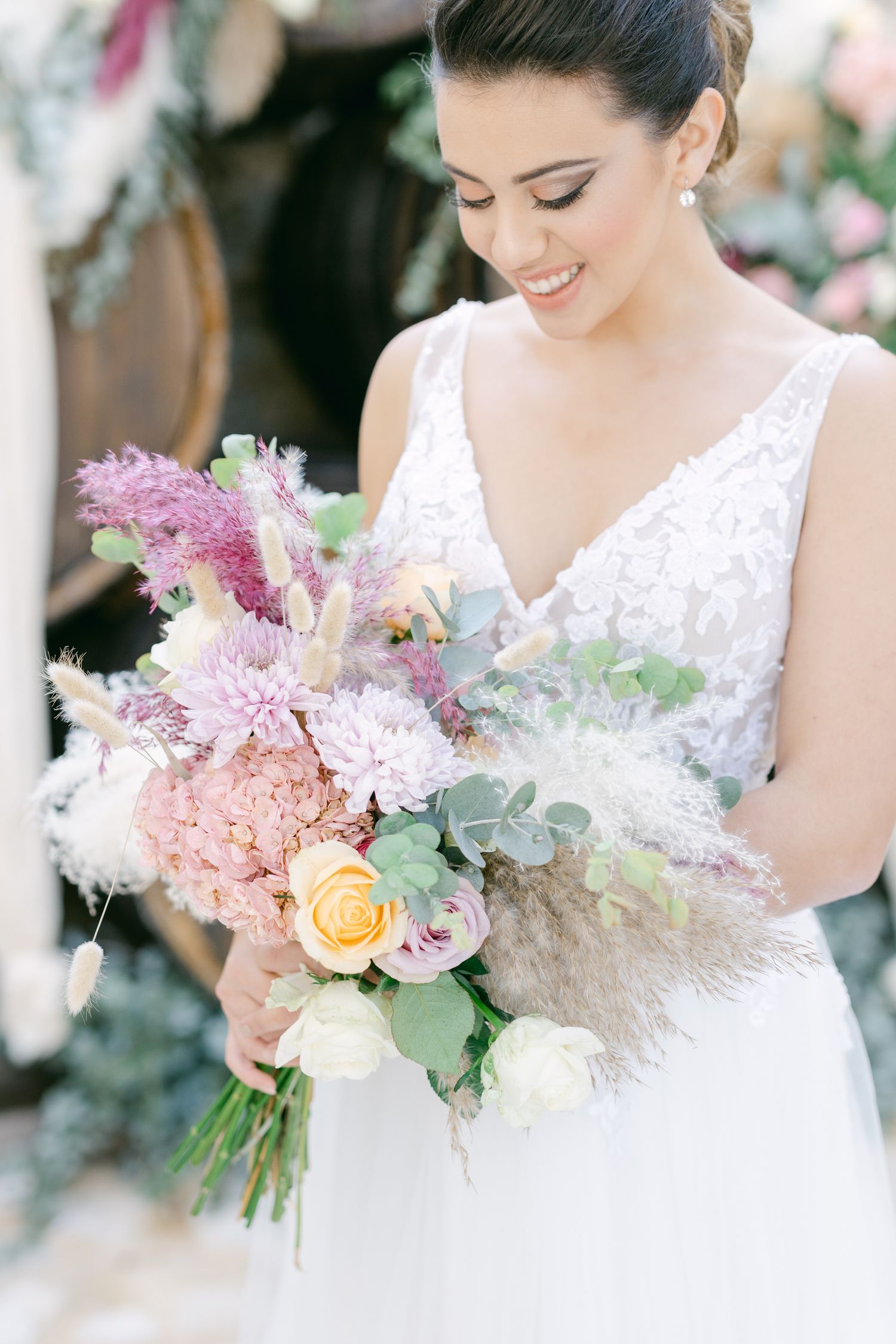A bridal bouquet features soft pink and peach flowers with delicate greenery.