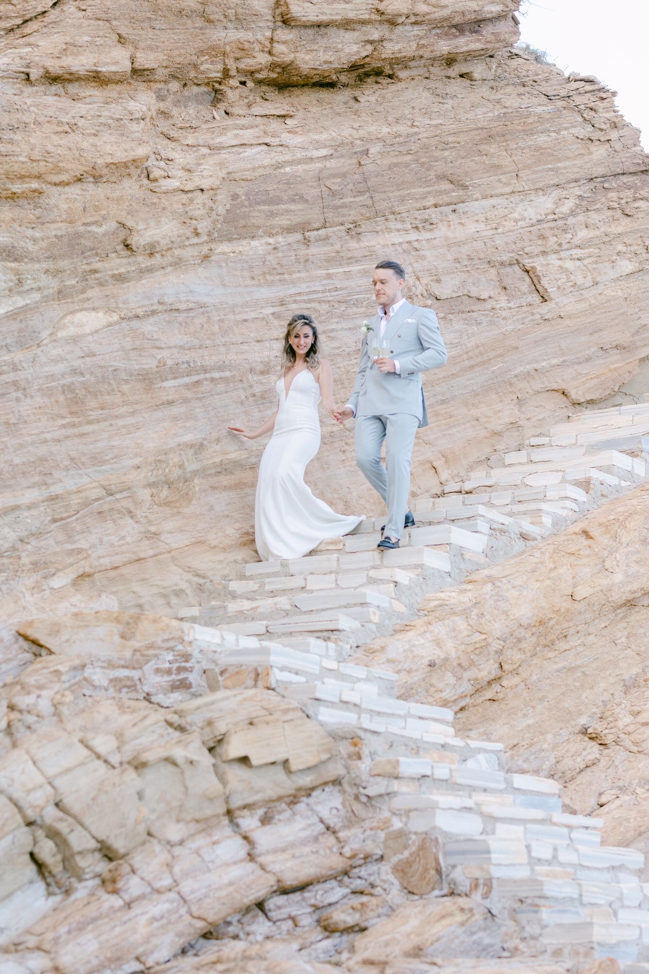 A couple ascending white stone steps carved into a natural rock formation.