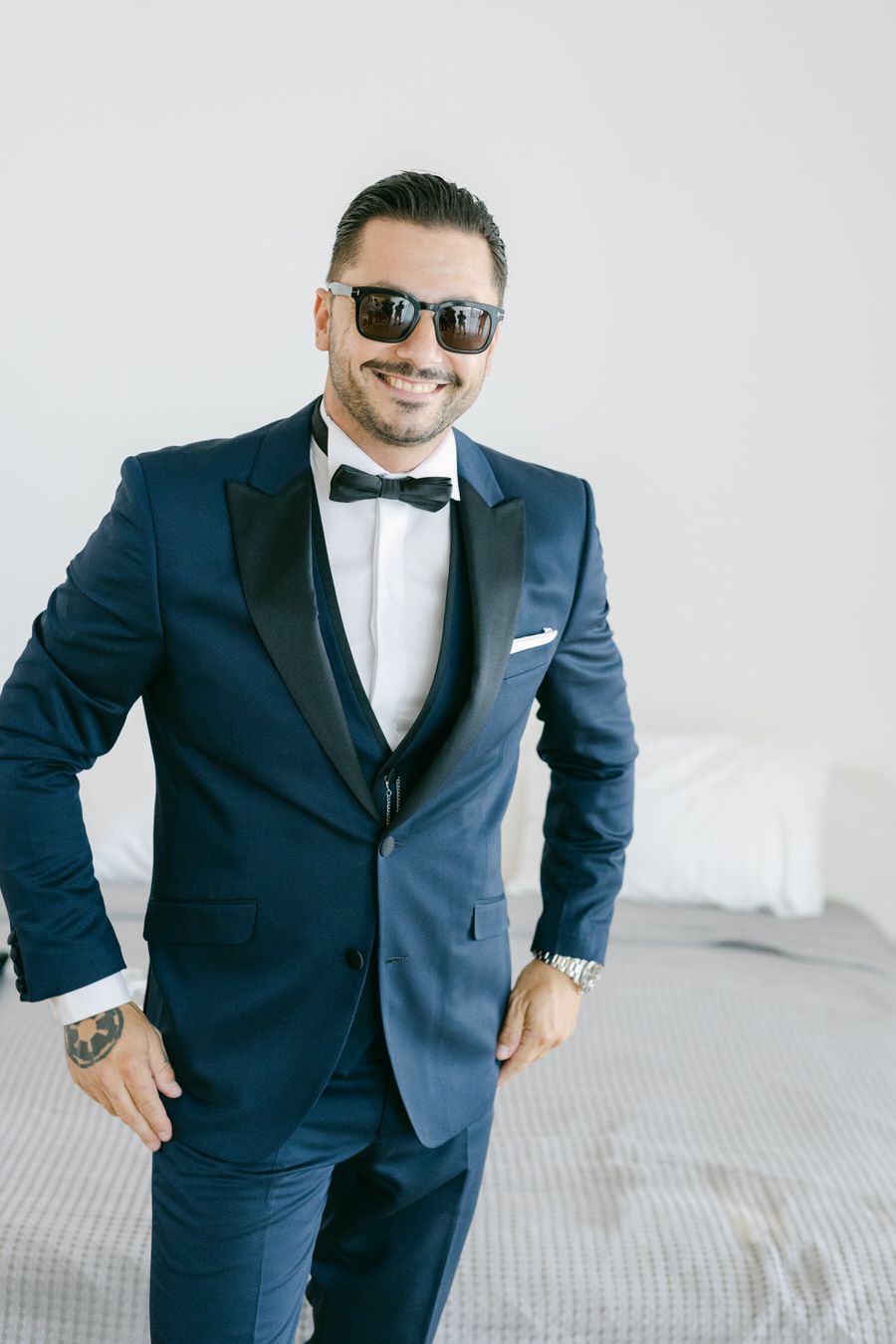 A formal navy blue tuxedo with black bow tie and white dress shirt styled for a special occasion.