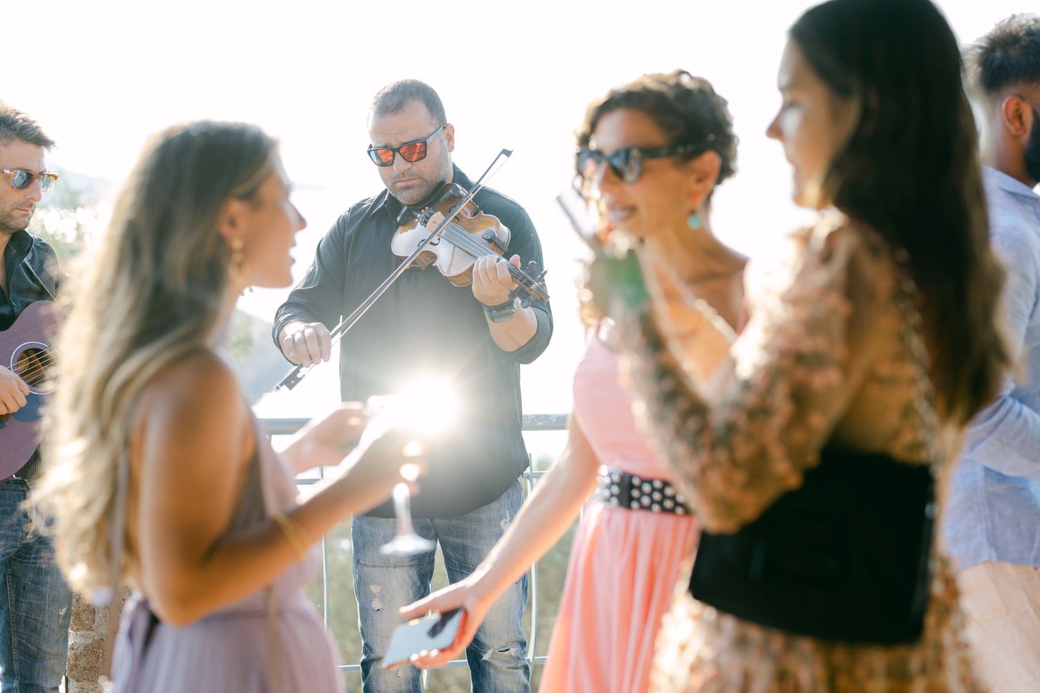 Wedding guests mingling and socializing during outdoor reception celebration.