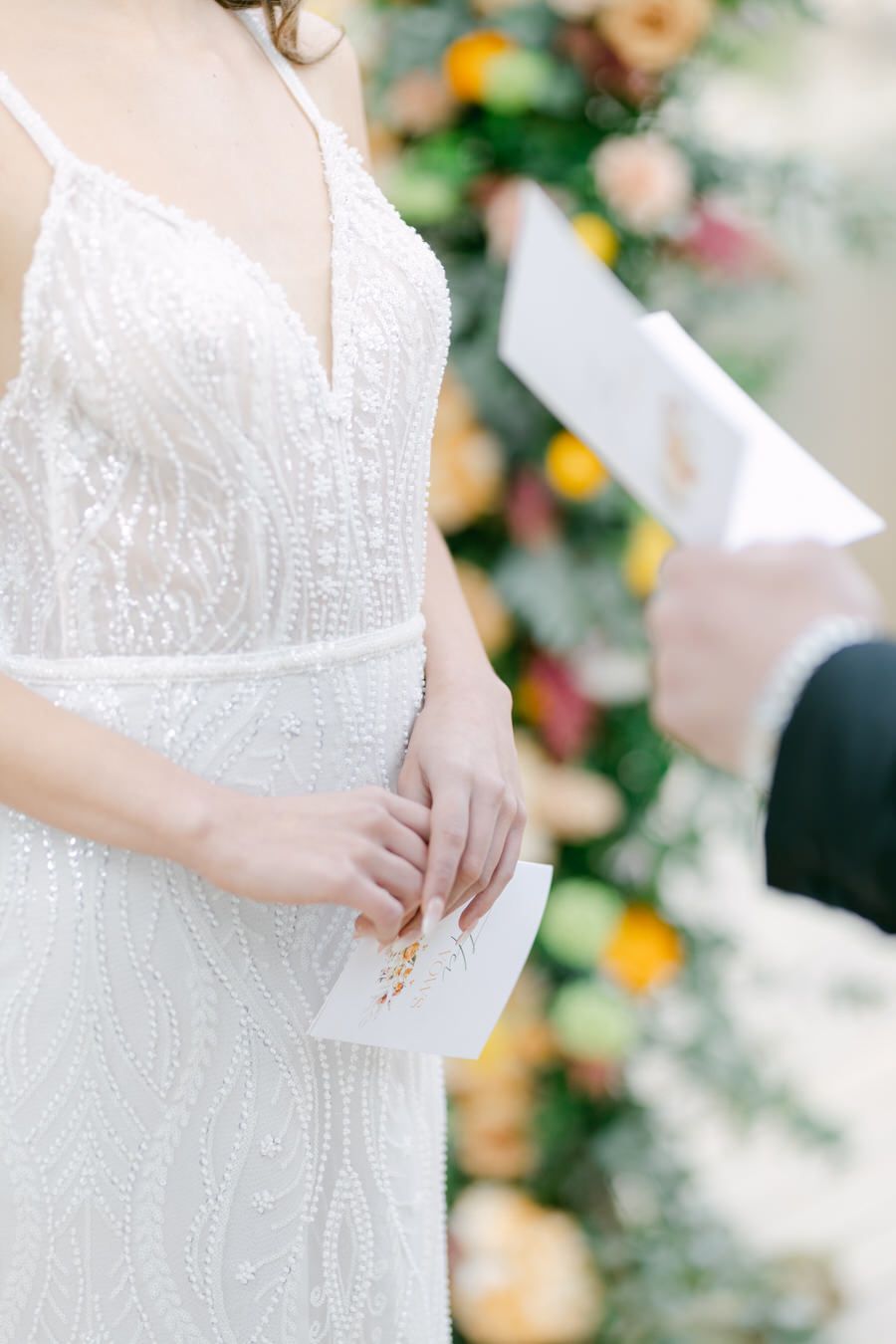 Close-up detail of intricate beaded lace on white wedding gown.