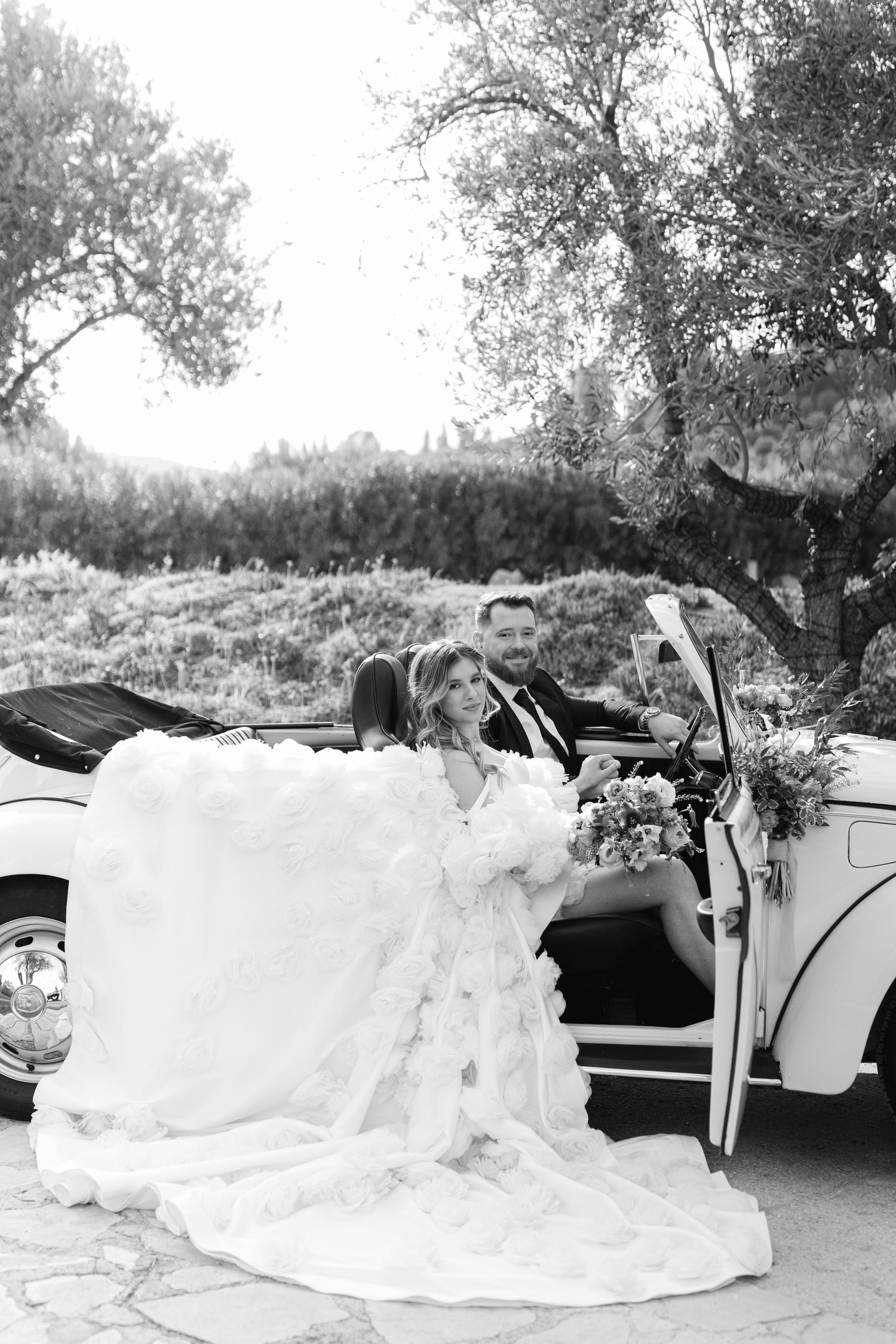 A classic white vintage car decorated for a wedding with a flowing white gown draped over the side. Nasioutzik Mansion. Κτήμα Νασιουτζικ.