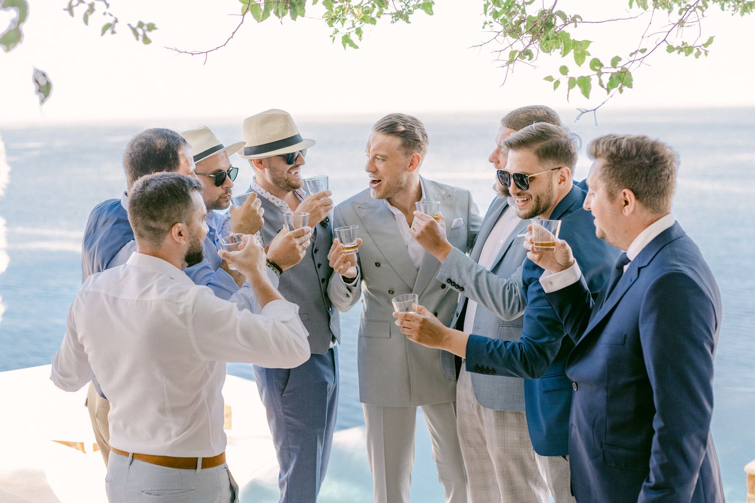 Group of well-dressed guests toasting at an outdoor celebration.