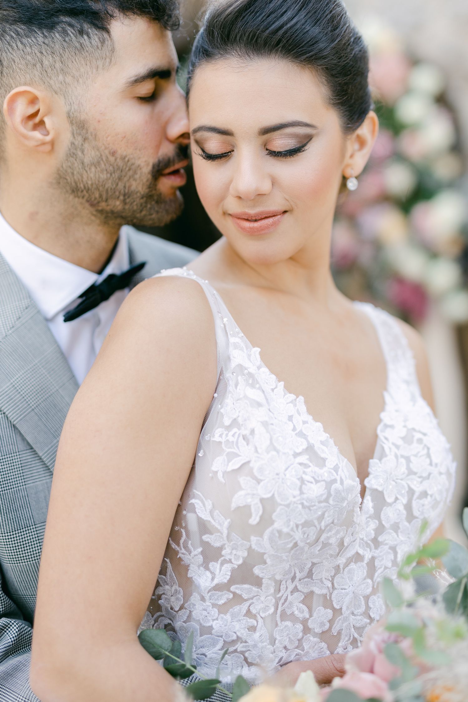 Intimate wedding portrait showing delicate lace details and tender embrace.