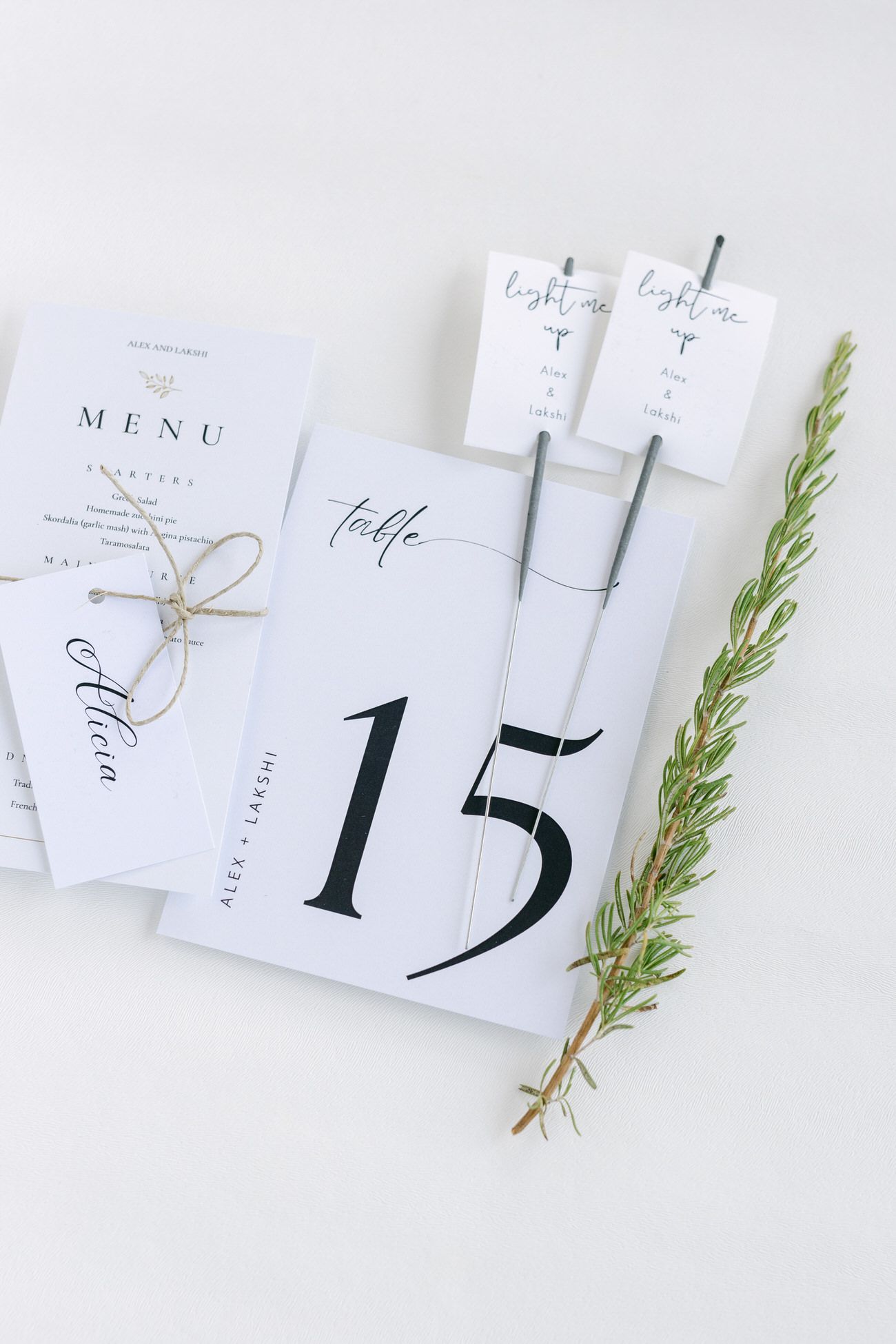 Minimalist wedding stationery set with table number 15 and menu cards decorated with greenery.