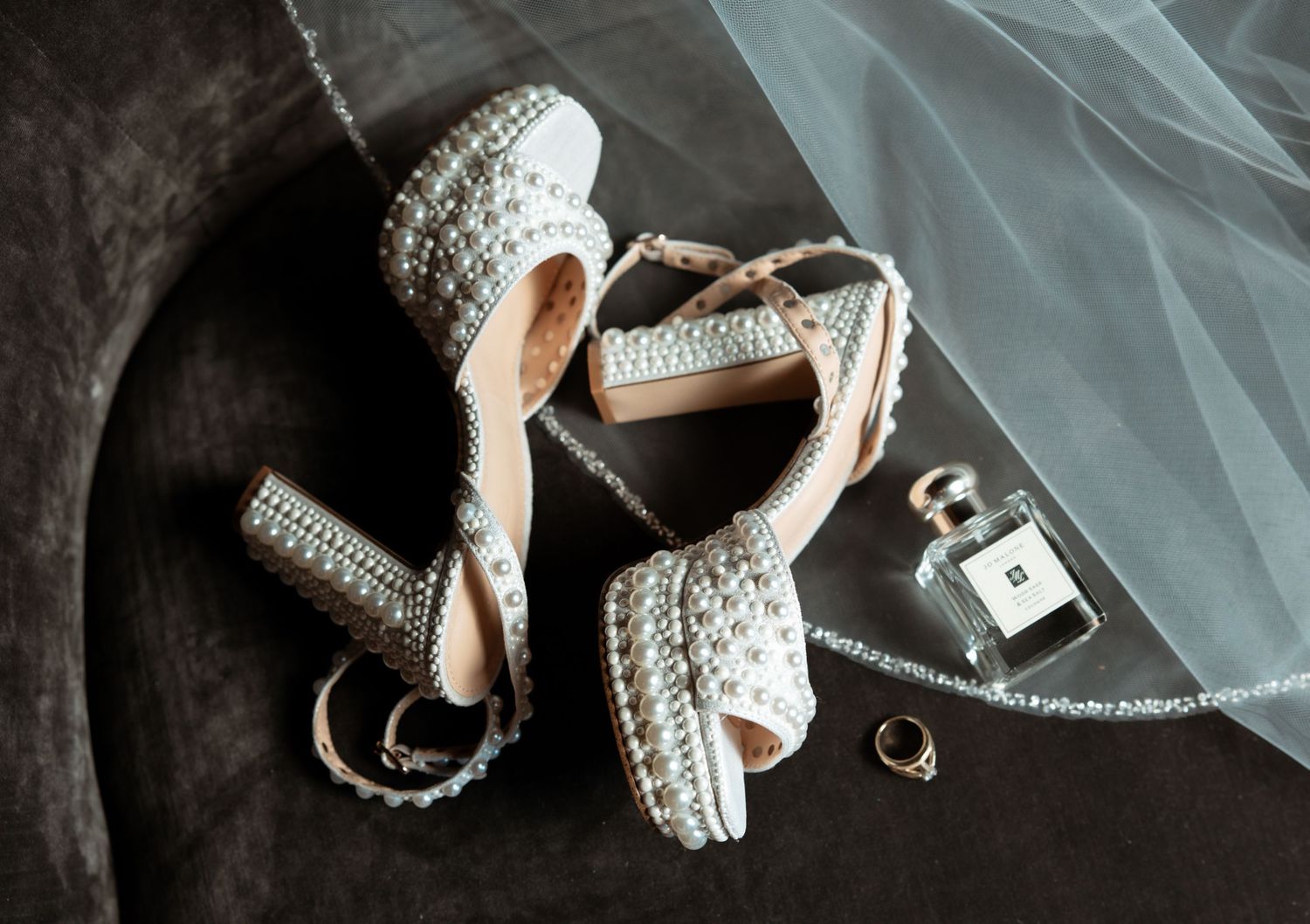 A collection of wedding rings and engagement rings displayed on various surfaces with romantic lighting and styling.