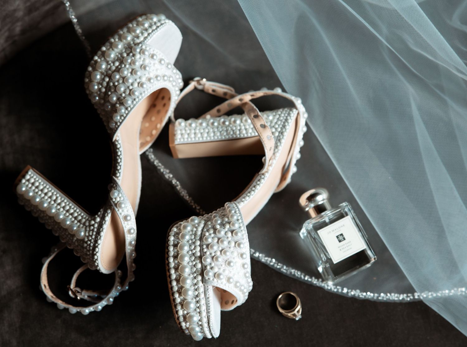 Close up view of silver rhinestone studded platform high heels arranged in different angles on dark background.
