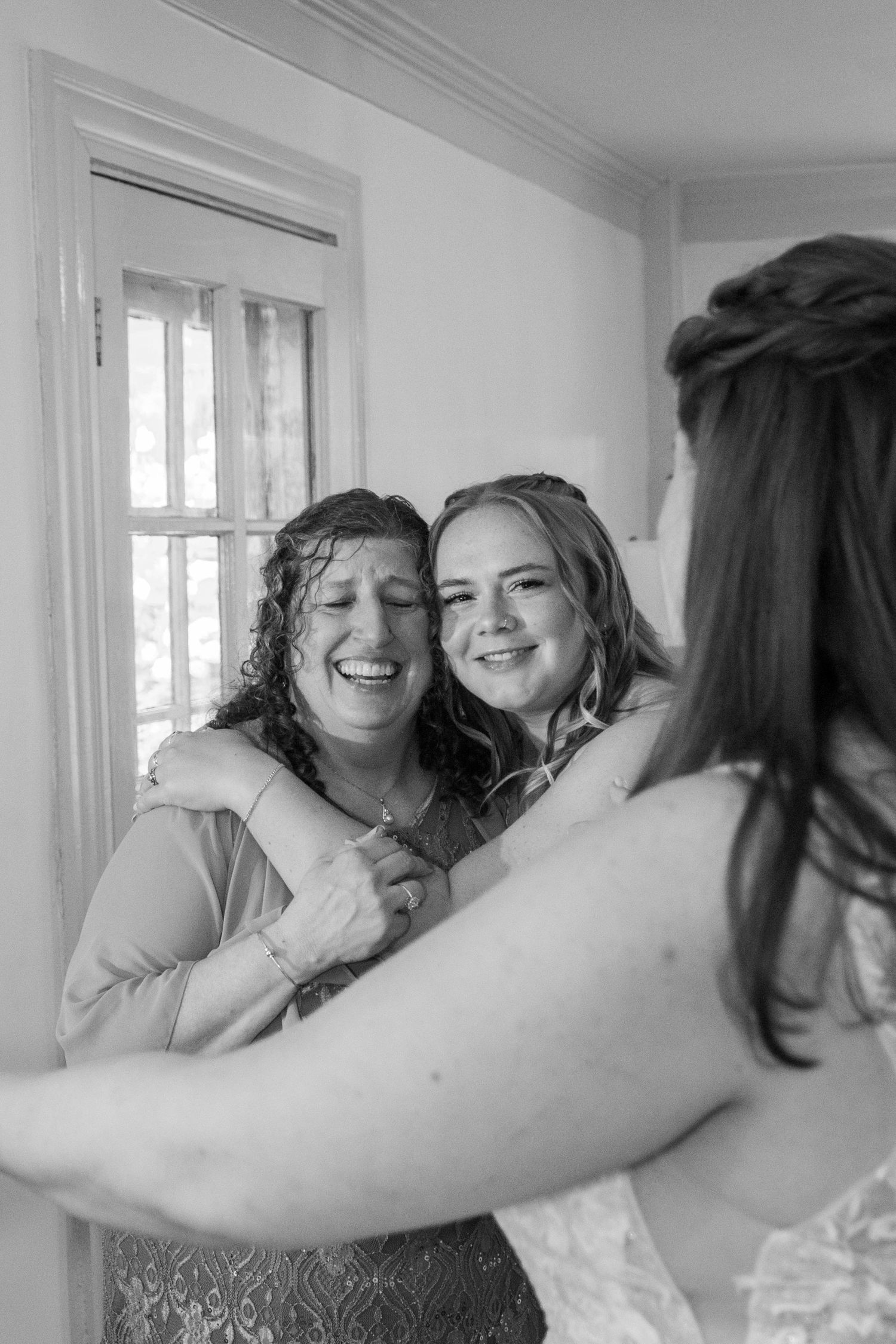 Black and white candid moment of joyful laughter in a bright room.