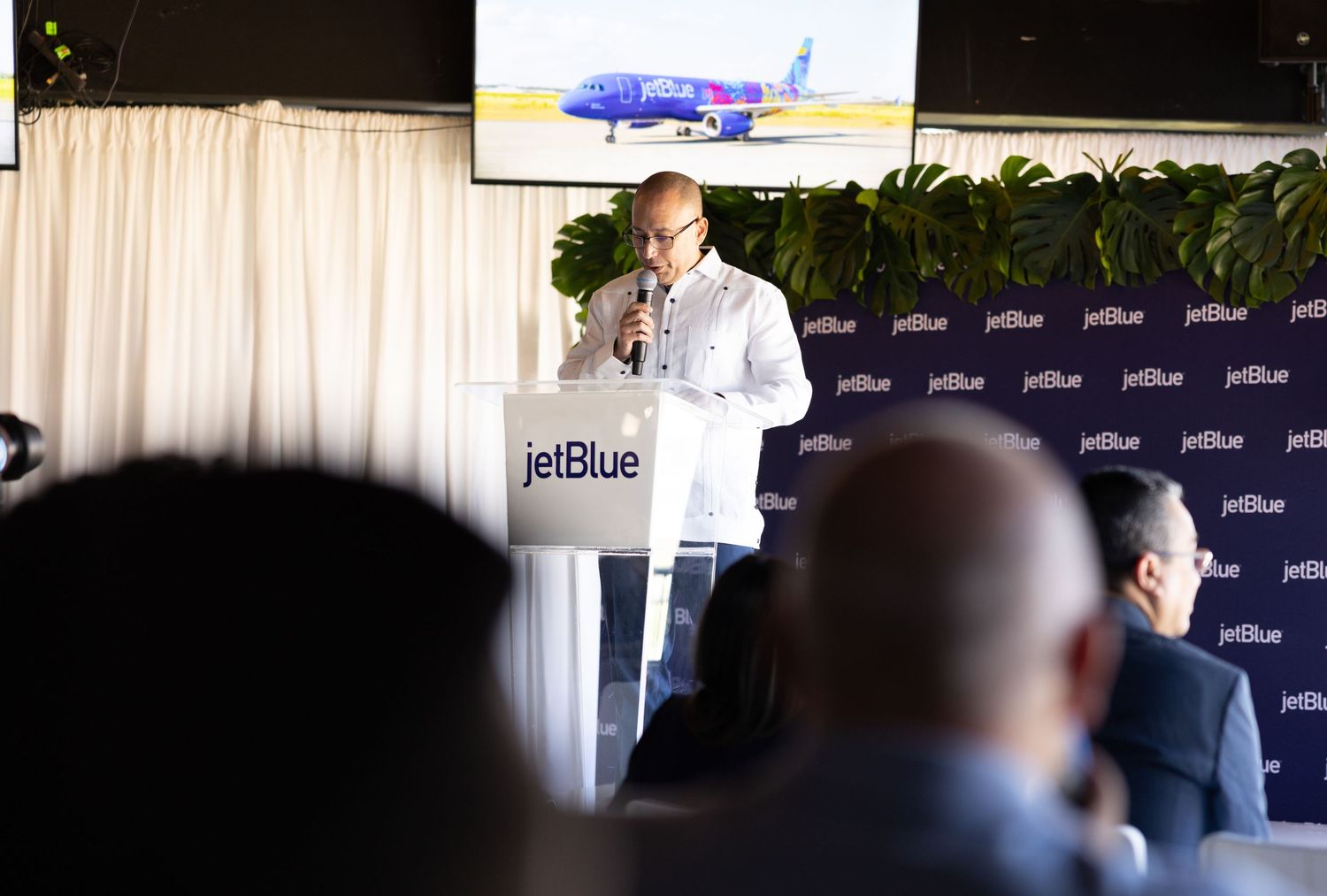 JetBlue corporate event with presentation screens and audience.