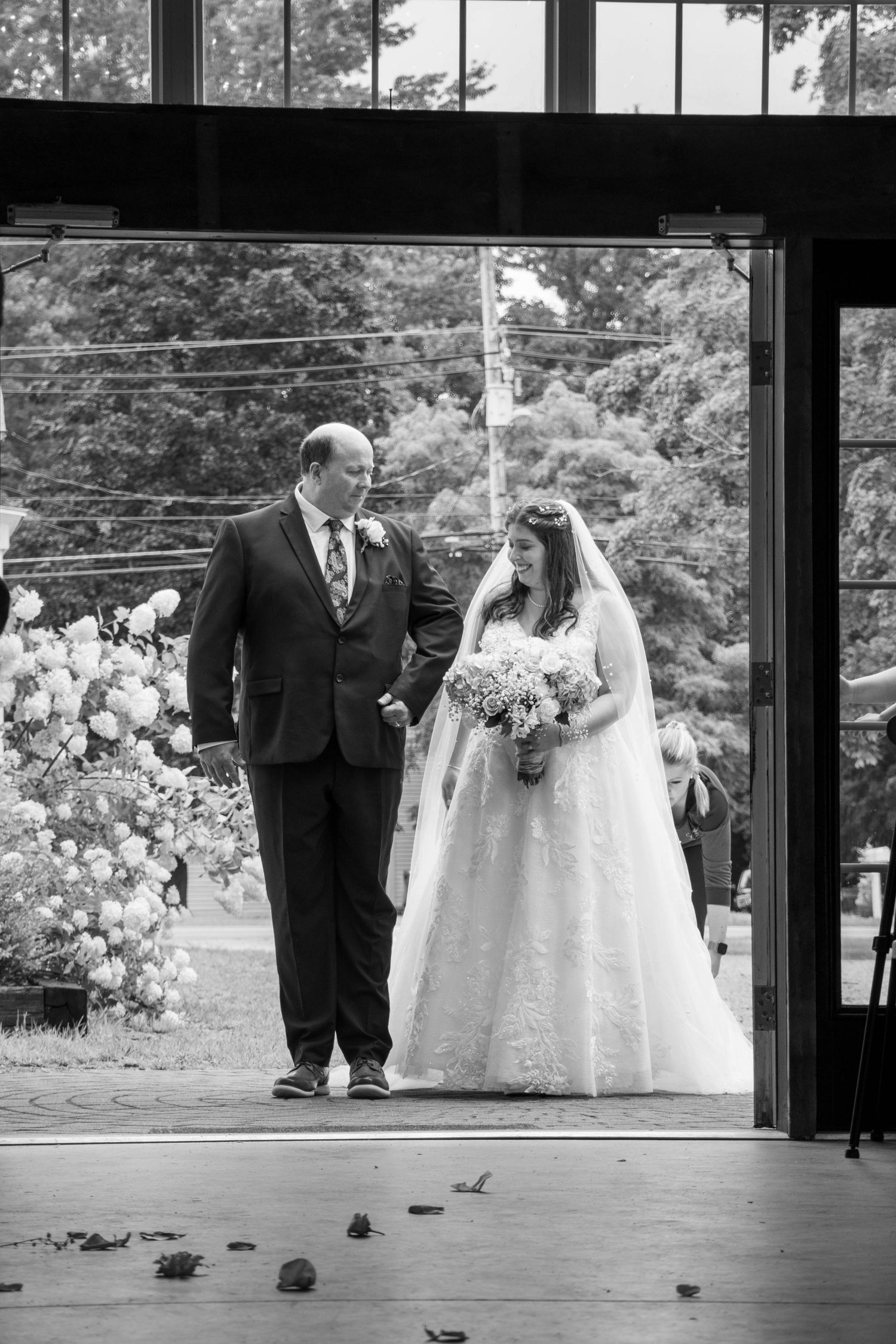 Black and white wedding ceremony entrance with floral arrangements.