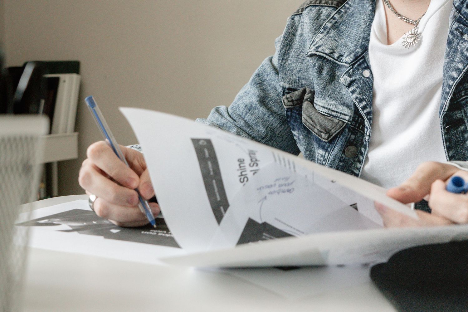 Professional writing with pen and paper at desk showing closeup of hands.