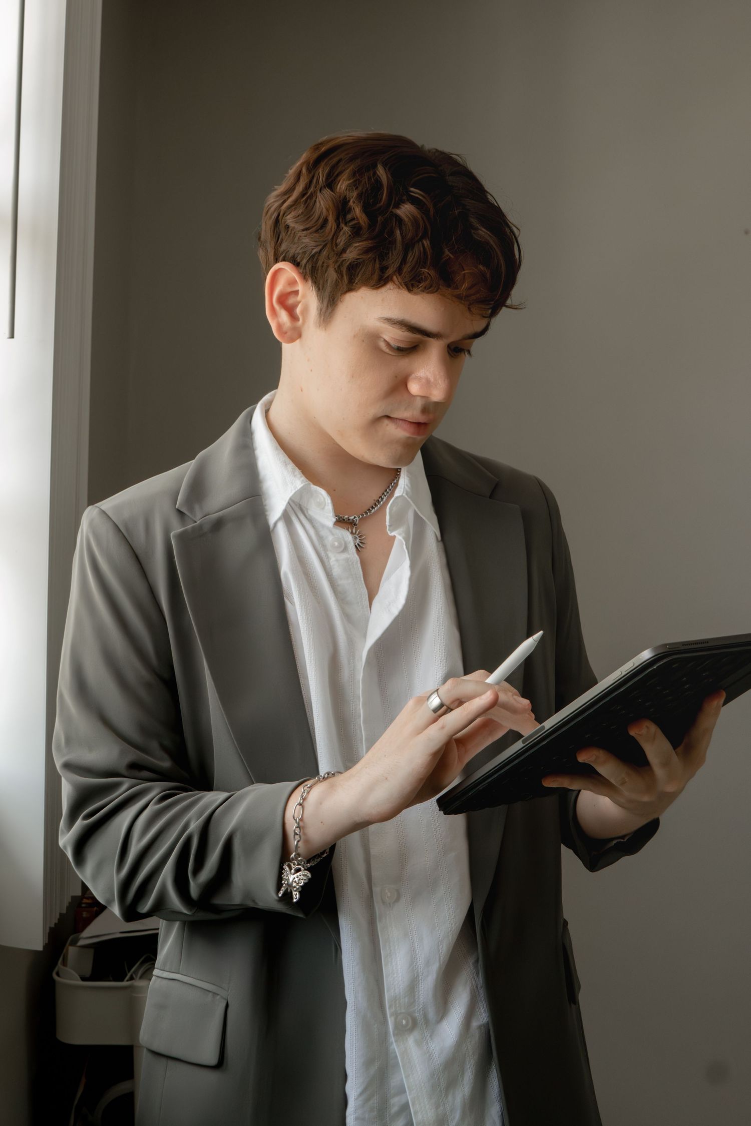 Person in grey blazer and white shirt reading from an iPad.