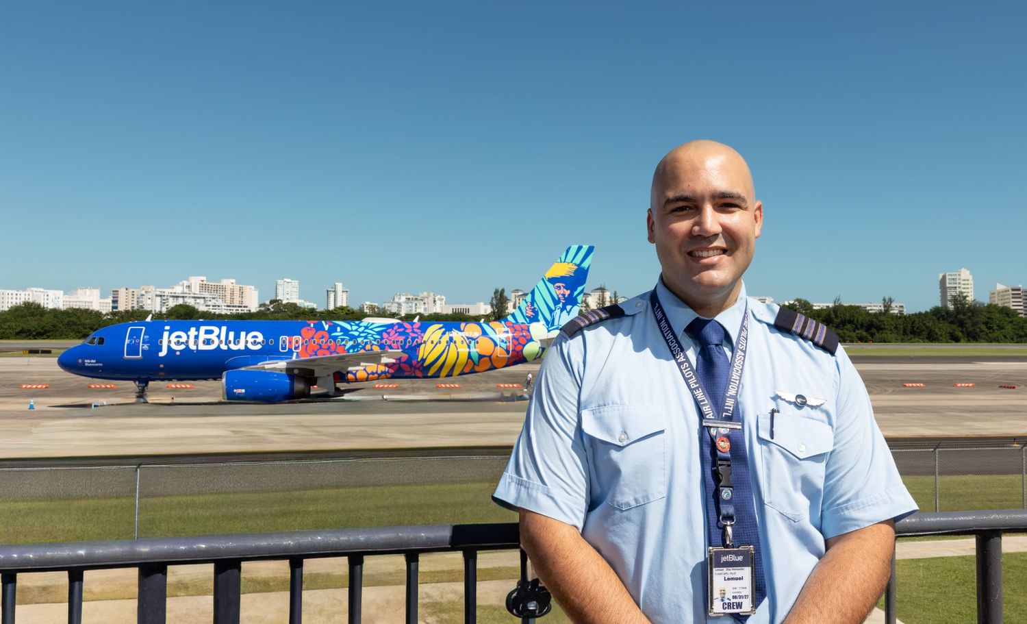 JetBlue aircraft and airline staff on sunny tarmac.