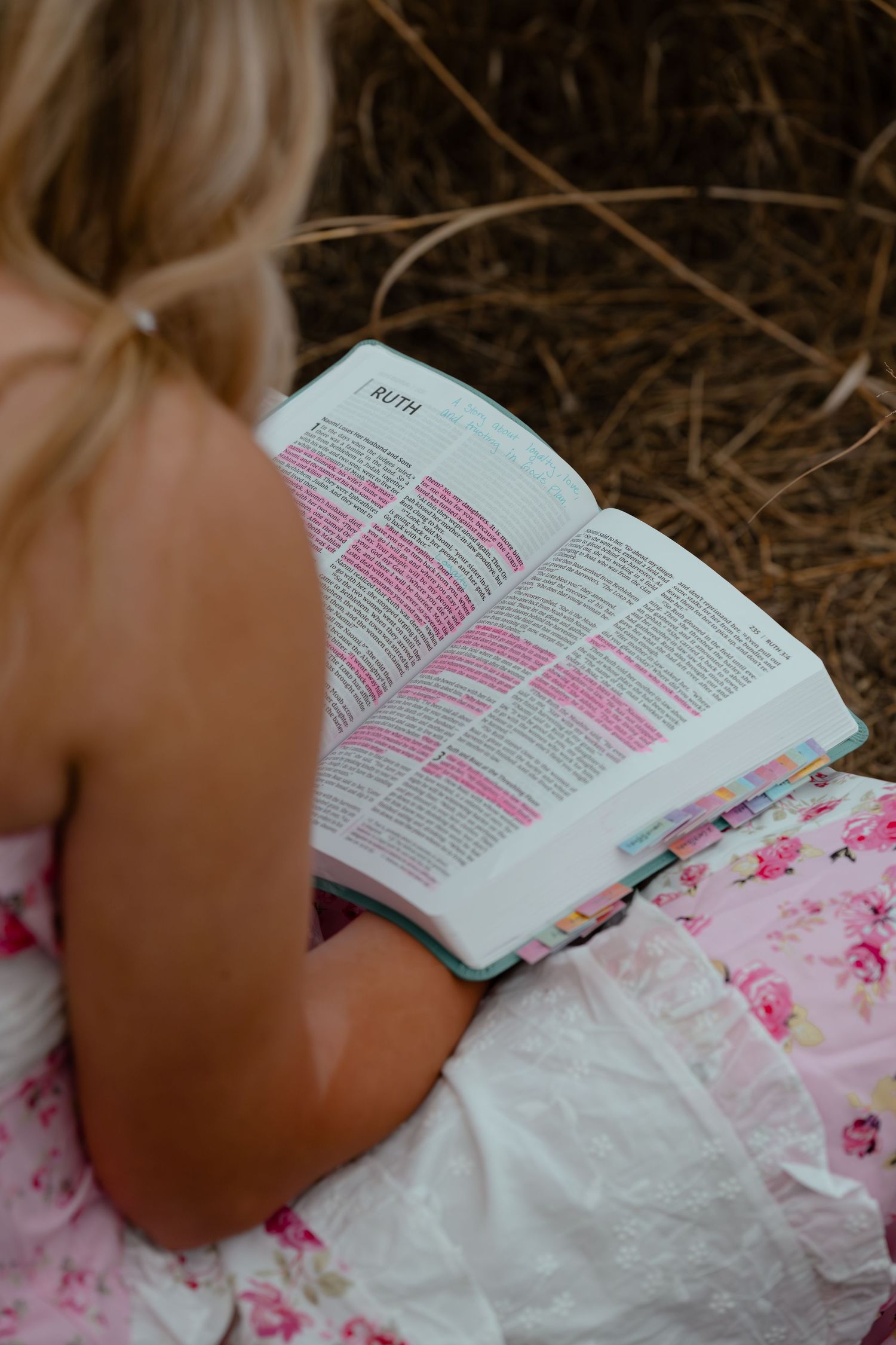 A pink floral dress and Bible study scene in natural lighting.