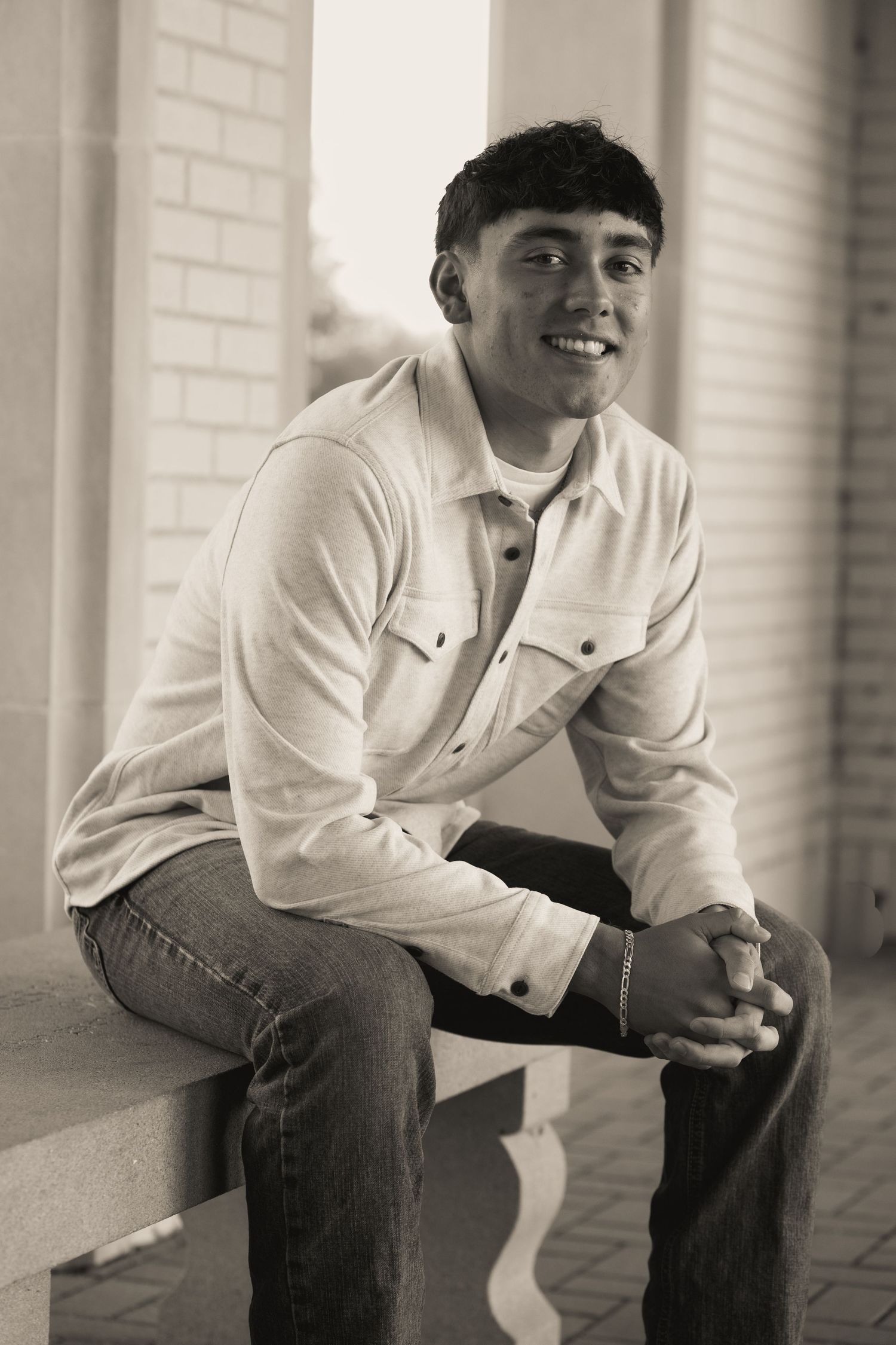 A casual portrait in black and white of someone sitting on a porch step.
