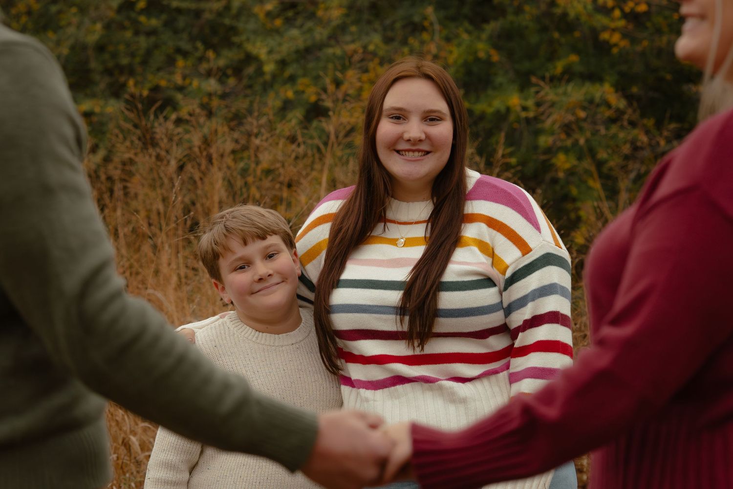 Family members in cozy sweaters gather together during fall season.