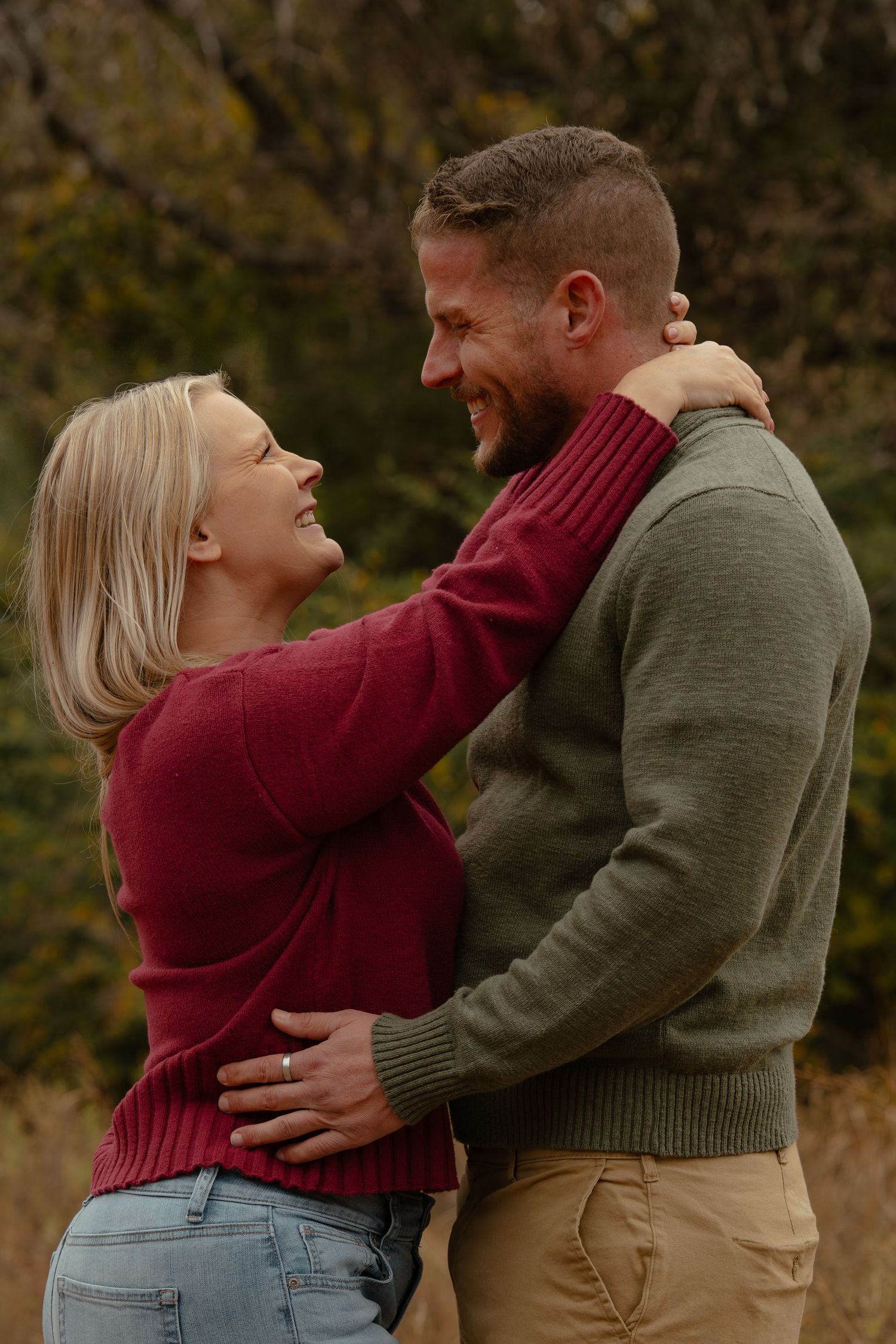 Couple sharing intimate embraces and laughter during autumn photo session.