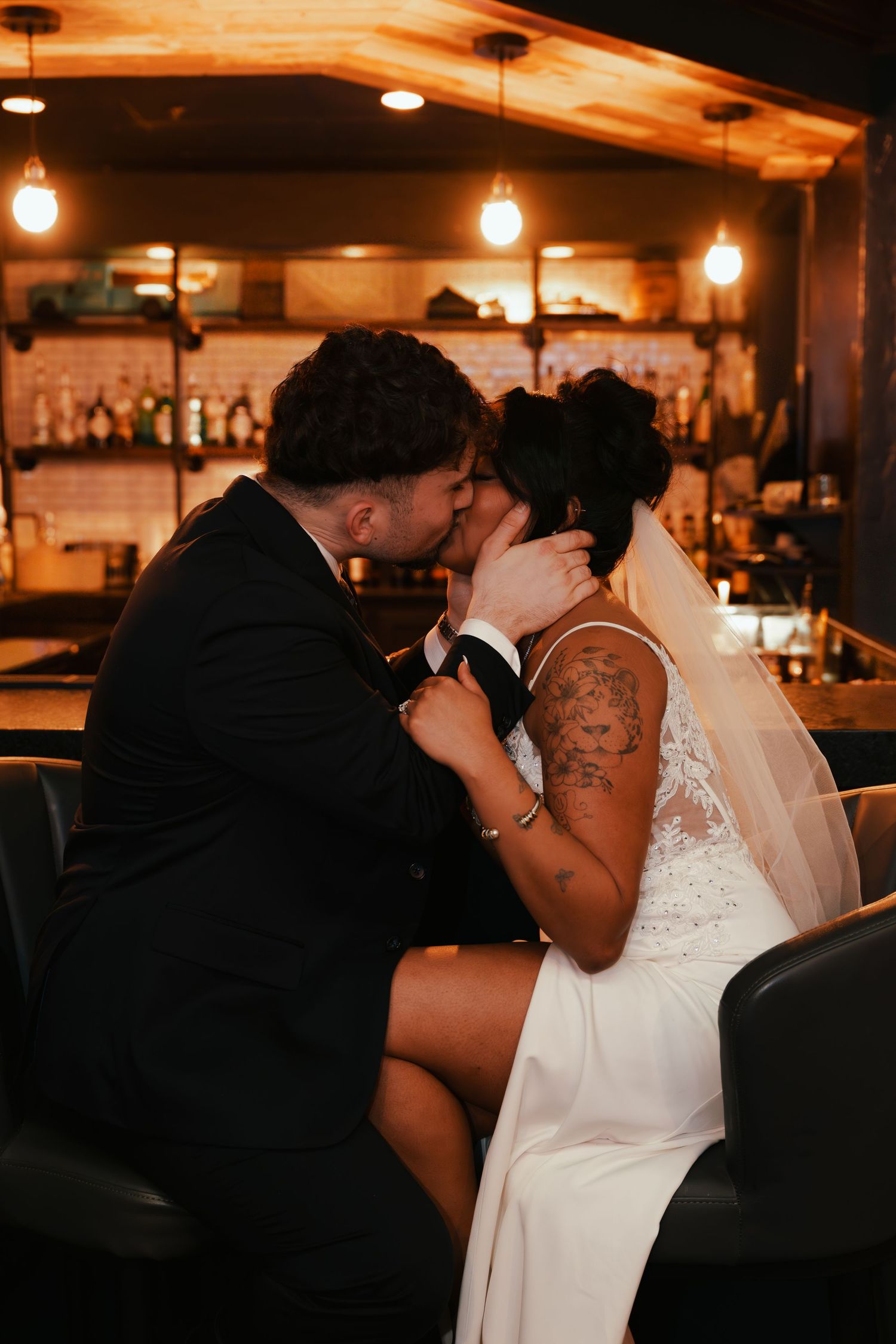 A romantic sequence of five wedding photos showing a couple sharing intimate kisses in a dimly lit venue.