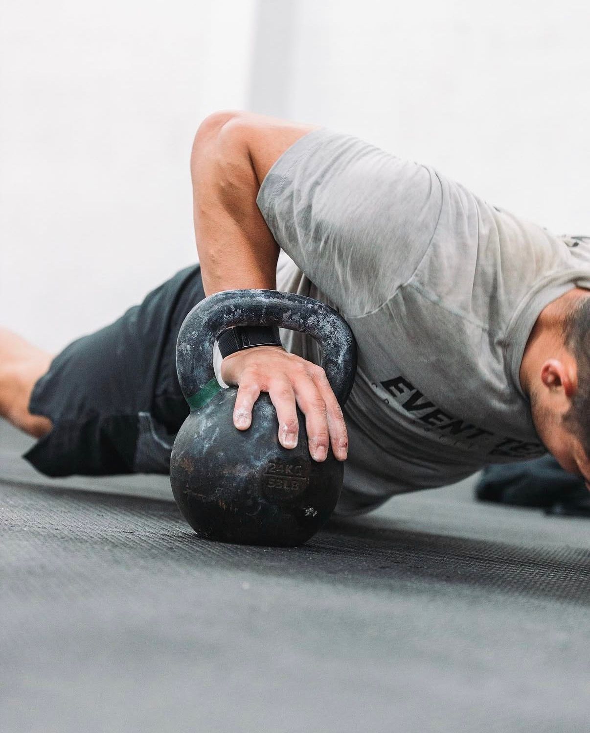 Fitness demonstration showing proper form for medicine ball exercises on grey floor.
