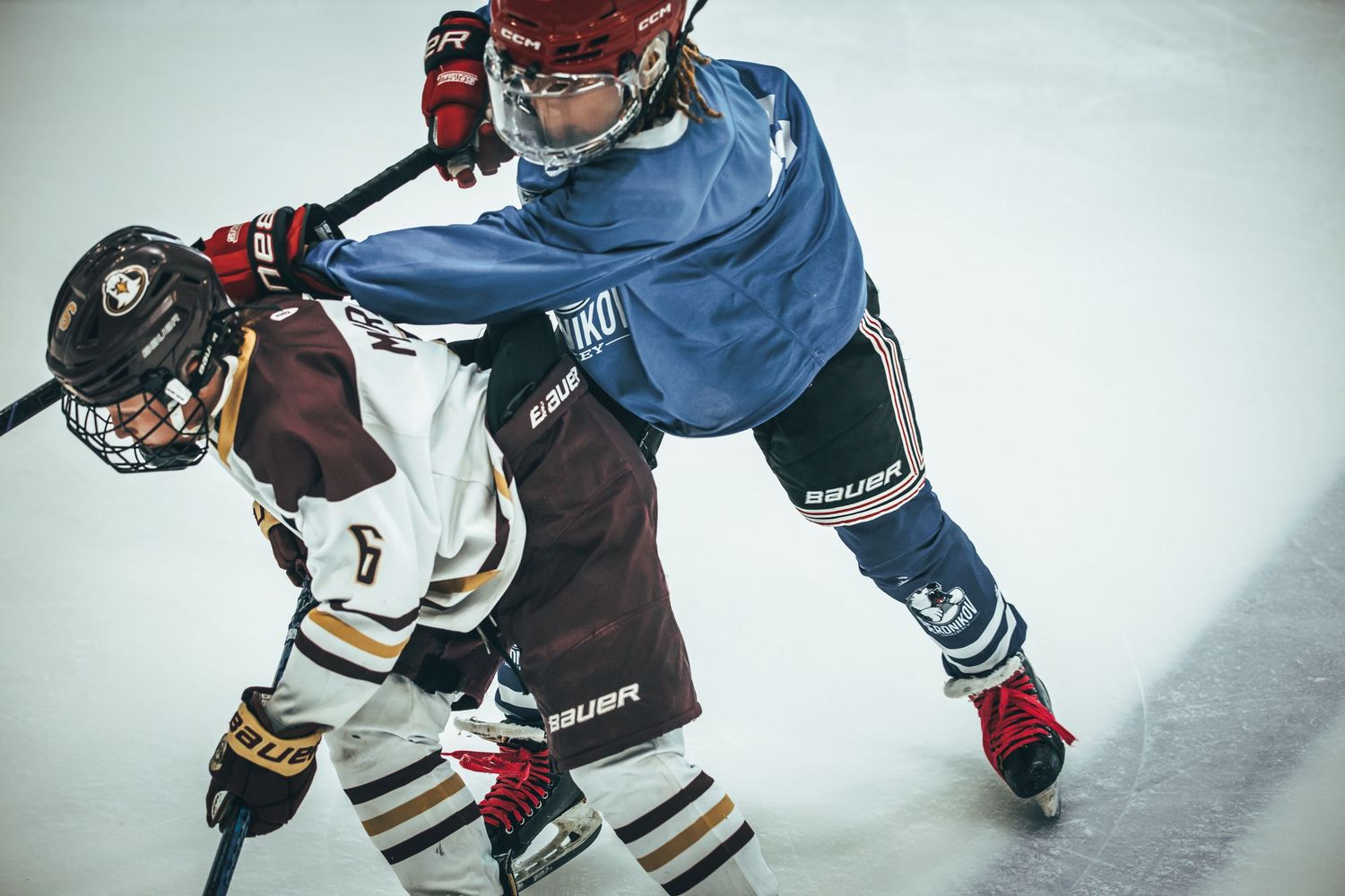 Hockey players battle for control of the puck during an intense game on the ice rink.