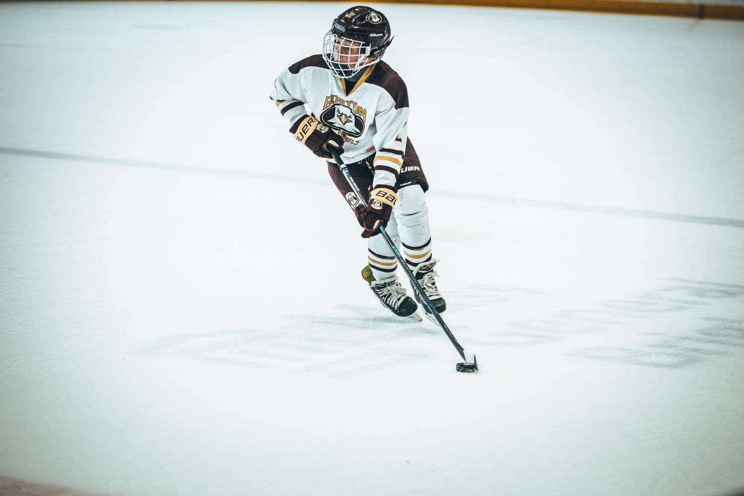 A hockey player in black and white uniform skates on ice during a game, captured in multiple action shots.