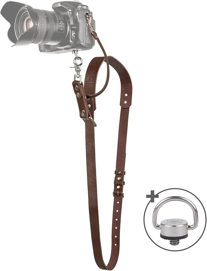 Brown leather camera neck strap with silver hardware and tripod mount adapter, compatible with DSLR cameras.