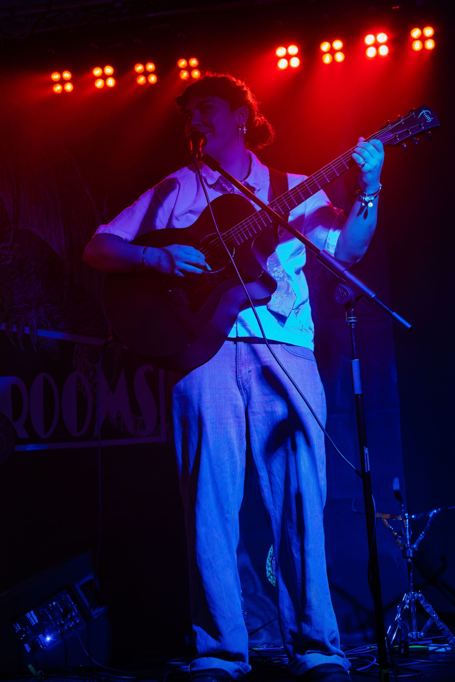 Concert stage bathed in red and blue lighting with performers creating a dramatic atmosphere.