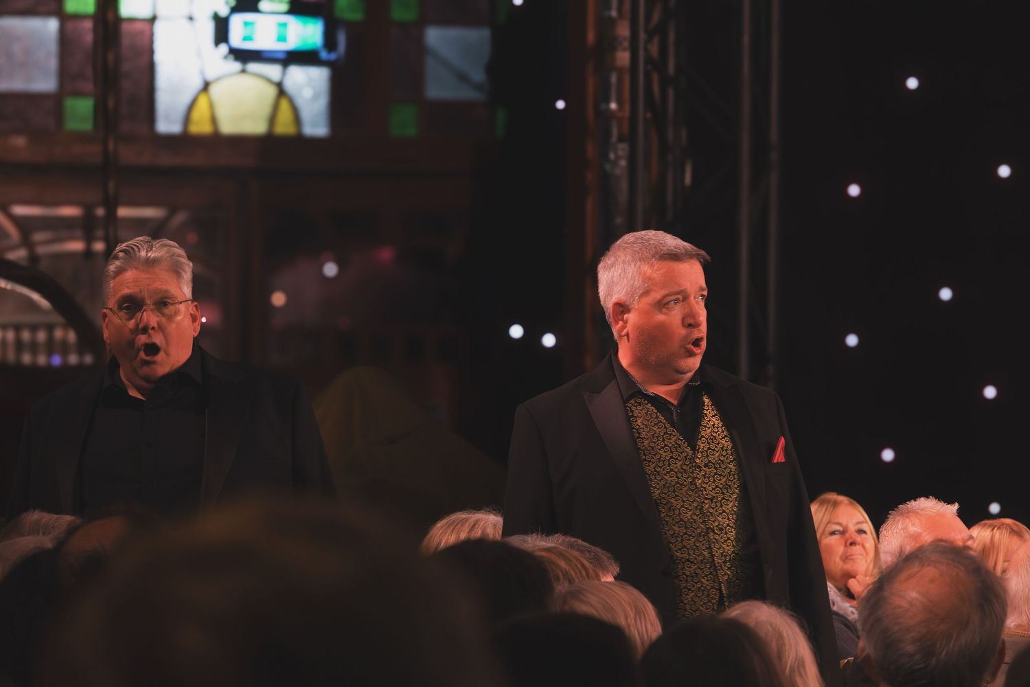 Performers stand among the audience during an intimate concert performance.