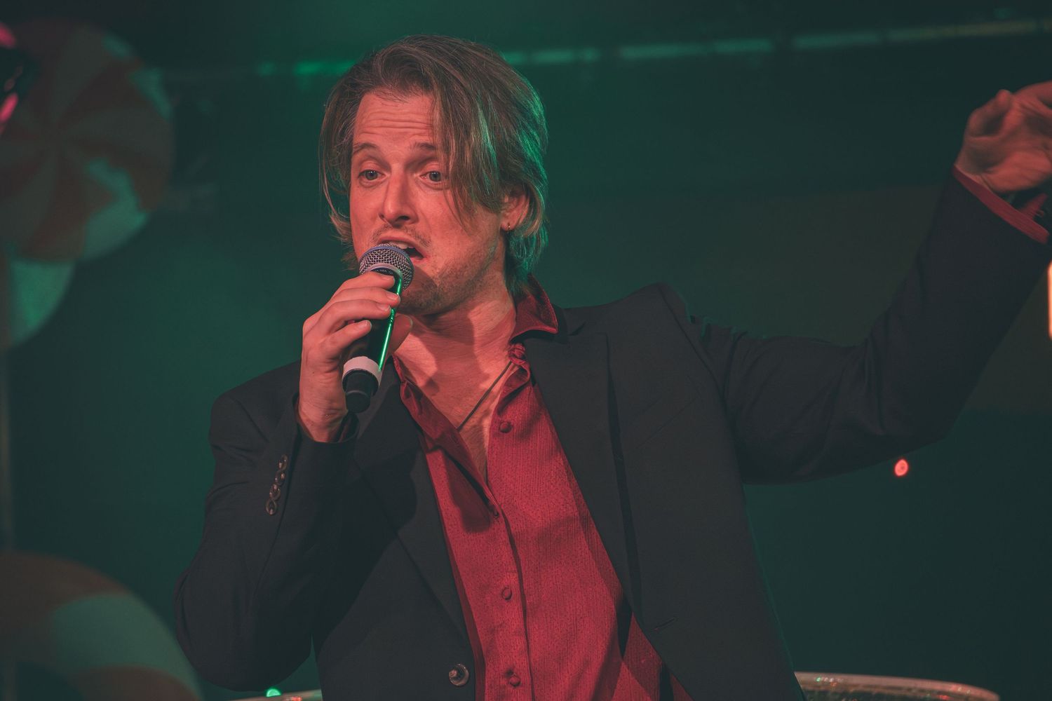 Dark moody stage performance with dramatic green lighting effects.