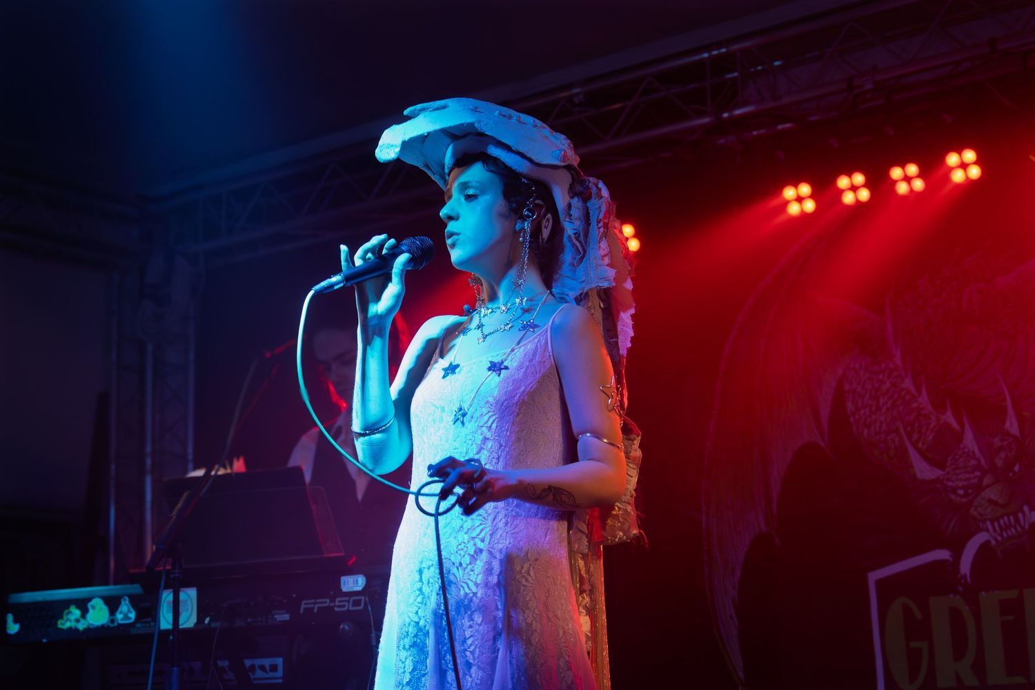 Musical performance on stage with dramatic lighting effects creating a blue and red atmosphere.