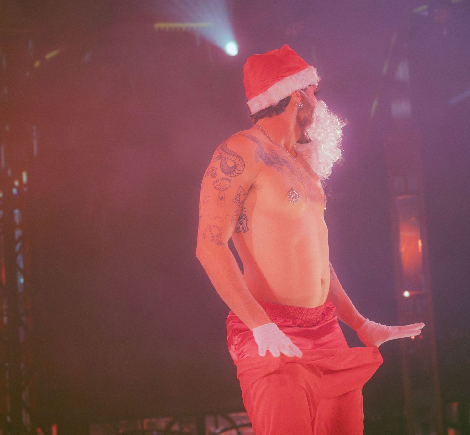 Performer in red costume moving dynamically on a dimly lit stage.