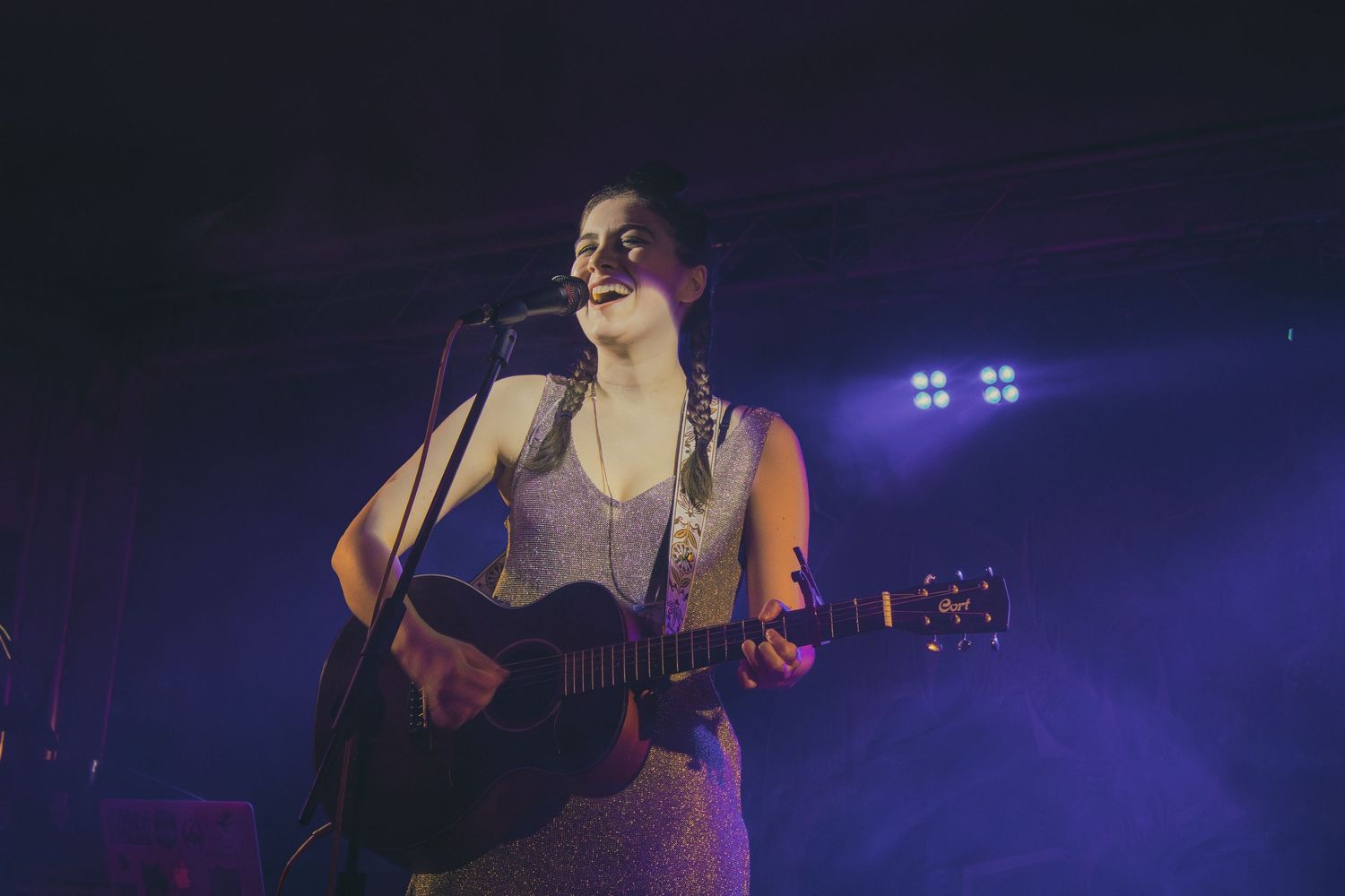 A performer on stage bathed in blue lighting during a live music performance.